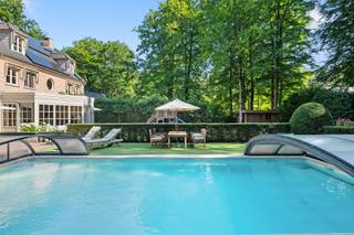 Gelijkvloers:Royale inkomhal met gastentoilet en handenwasser. Lichtrijke leefruimte met zithoek en open haard, aansluitend op de ruime leefkeuken...