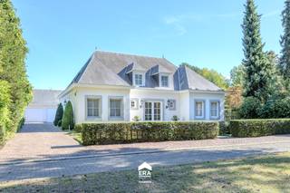 <u>Lommel:</u> Statige villa met openluchtzwembad en luxe afwerking<br /><br />Gelegen in bosrijk villapark op 5 minuten van de Nederlandse grens.<br /><br /><u>Bijzonderheden:</u>
<ul><li>Royale inkom met marmeren vloer</li><li>Ruime leefruimte (70m²) met marmeren vloer en open haard</li><li>Aparte TV-hoek/ kantoorruimte</li><li>Masterbedroom met aansluitend badkamer en dressing op het gelijkvloers</li><li>3 slaapkamers en badkamer op verdieping</li><li>Aparte wasplaats</li><li>Dubbele vrijstaande garage met zolder</li><li>Kelder en kruipruimte onder de gehele woning</li><li>Zuidelijk georiënteerde privacybiedende tuin met openluchtzwembad en buitendouche</li><li>Groot open terras met zonneluifel en overdekt terras met screens</li></ul>