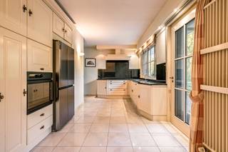 Charmante villa met ruime uitbreidingsmogelijkheden op een uniek privé-domein grenzend aan natuurgebied te Schilde<br /><br />In één van de meest gegeerde en residentiële buurten van Schilde, discreet gelegen aan het einde van een doodlopende straat, bevindt zich deze karaktervolle villa op een perceel van 4968m². Een locatie waar rust, privacy, natuurbeleving en comfort naadloos samenkomen.<br /><br />Indeling gelijkvloers:<br />De villa verwelkomt u via een ruime en lichtrijke inkomhal met vestiaire en gastentoilet. Vanuit hier bereikt u de aangename leefruimte met open haard en grote raampartijen, die zorgen voor een prachtig uitzicht op de fraai aangelegde tuin. Aansluitend bevindt zich een sfeervolle leefveranda, volledig omringd door schuiframen en voorzien van automatische zonnescreens, zodat u het hele jaar door geniet van een maximale lichtinval en een harmonieus zicht op het groen.<br /><br />De volledig uitgeruste keuken biedt eveneens zicht op en directe toegang tot het terras en wordt vergezeld door een praktische berging. Aansluitend bevindt zich een tweede gezellige leef- en eetruimte, voorzien van een houtkachel, wat deze ruimte bijzonder warm en uitnodigend maakt. Tevens is er een aparte bureauruimte, ideaal voor wie praktijk- of kantooractiviteiten aan huis wenst. De inpandige garage met automatische poort biedt plaats aan twee voertuigen.<br /><br />Eerste verdieping:<br />De nachthal leidt naar de master bedroom met ensuite badkamer, aangevuld met drie comfortabele, volwaardige slaapkamers. Daarnaast is er een tweede badkamer met douche en een bijzonder ruime, functionele wasplaats.<br /><br />Tuin en buitenbeleving:<br />De zuidwest-georiënteerde tuin vormt een ware oase van rust, met weidse vergezichten en een bijzonder harmonieuze groenbeleving. De tuin werd smaakvol aangelegd.<br /><br />Bijzonderheden:<br />- Maximale privacy, prestigieuze ligging &amp; ideale zonoriëntatie<br />- Renovaties: 1997 (aanbouw leefruimte) – 1999 (gedeeltelijk buitenschrijnwerk)<br />- Verwarming op aardgas (Viessmann) via radiatoren en convectoren<br />- Dubbele beglazing (hout &amp; aluminium)<br />- Rolluiken aanwezig<br />- Videofonie &amp; automatische toegangspoort<br />- Oprit met plaats voor ca. 6 wagens<br />- Bergzolder toegankelijk via vlizotrap