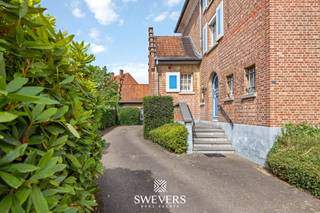 Voor meer info en foto’s, surf naar www.swevers.be – vlak aan de B-mine in Beringen bevindt zich deze karaktervolle ingenieurswoning terug. Een statige open bebouwing met een bewoonbare oppervlakte van 269 m², gelegen op een ruim perceel van 1.032 m². De woning uit 1930 biedt een uitstekende basis voor wie op zoek is naar veel ruimte en de mogelijkheid om volledig naar eigen smaak op te frissen. Via de inkomhal bereikt u de leefruimtes op het gelijkvloers. Hier vindt u een voorkamer die ideaal is als bureau of speelkamer, een ruime salon, een woonkamer van samen circa 42 m² en een keuken van ongeveer 15,6 m² met aansluitende berging en toegang tot tuin. Verder zijn er twee aparte toiletten aanwezig. Op de eerste verdieping bevinden zich drie ruime slaapkamers van circa 23 m², 18,75 m² en 15,6 m², evenals een badkamer met douche, ligbad, toilet en wastafel. De tweede verdieping biedt nog twee extra kamers onder het dak, bereikbaar via een vaste trap. Deze ruimtes kunnen perfect ingericht worden als bijkomende slaapkamers, hobbyruimte of bureau. In totaal beschikt de woning over vijf slaapkamers. Extra bergruimte is voorzien in de ruime kelder van ongeveer 83 m² met meerdere praktische ruimtes. Daarnaast is er een vrijstaande garage aanwezig. De westgerichte tuin biedt volop mogelijkheden om een aangename buitenruimte te creëren waar u optimaal van de namiddag- en avondzon geniet. De ligging vormt een extra troef met openbaar vervoer op 100 meter, scholen op 800 meter, restaurants op 450 meter, winkels op 2,4 kilometer en een vlotte verbinding naar de autosnelweg op slechts 2 kilometer. Bovendien ligt de populaire B-Mine-site recht tegenover de woning. Voor meer informatie, bel 011 255 155. Bron bewoonbare oppervlakte: EPC – verslag. Dit pand is onderworpen aan de renovatieverplichting van de Vlaamse overheid voor residentiële gebouwen (behoudens bij sloop binnen 5 jaar na de aankoop). Consulteer voor meer informatie de website van het Vlaams Energie- en Klimaatagentschap via https://www.vlaanderen.be/een-huis-of-appartement-kopen/renovatieverplichting-voor-residentiele-gebouwen.