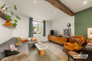 Deze charmante, witgeschilderde hoekwoning combineert authentieke Brugse gezelligheid met hedendaags wooncomfort. De woning geniet van een centrale ligging in het hart van Brugge en beschikt over een verrassend aangename stadskoer die dankzij de unieke indeling een volwaardig verlengde vormt van de leefruimte.<br /><br />Bij het binnenkomen bevindt zich een inkomhal met gastentoilet. Van hieruit komen we in de lichtrijke leefruimte met open keuken, die rechtstreeks in verbinding staat met de gezellige, omwalde stadskoer. Het grote raam kan volledig opengezet worden, waardoor binnen en buiten op een bijzonder aangename manier in elkaar overvloeien. <br /><br />Aansluitend aan de keuken bevindt zich een praktische berging/wasplaats met douche. De centrale stadskoer beschikt bovendien over een zijpoort naar de straatzijde.<br /><br />Op de eerste verdieping bevinden zich twee ruime slaapkamers, waarvan één uitgerust met maatkasten. Verder is er een volledig ingerichte badkamer met dubbele wastafel, ligbad, inloopdouche en toilet. Een afzonderlijke bureauruimte maakt het geheel compleet.<br /><br />Ook technisch beschikt de woning over een interessante basis. Zo is er centrale verwarming op aardgas, nieuw raamwerk, een conform gekeurde elektrische installatie, ventilatiesysteem D en een regenwaterput.<br /><br />Bovendien werden reeds een nieuwe voordeur en zijdeur voor de stadskoer besteld. Deze zijn inbegrepen in de verkoopprijs.<br /><br />Er dienen nog enkele afwerkingen te gebeuren, maar dit biedt tegelijk de mogelijkheid om de woning verder naar eigen smaak en wensen af te werken.<br /><br />