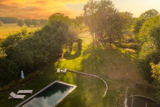 <div>LIGGING<br /><br />Deze villa is gelegen in het landelijke Laarne op een perceel van 5 336m2 met een goede 700M2 bewoonbare oppervlakte alsook een bijgebouw van 80m2 die veel mogelijkheden te bieden heeft.<br />De regio is rijk aan wandel- en fietsroutes alsook vlot bereikbaar met de wagen met de nabijheid van diverse invalswegen.<br /><br />VILLA<br /><br />De oorspronkelijke villa dateert van 1981, de landelijke architectuur is eveneens terug te vinden binnenin deze woning.<br />Deze villa is perfect voor wie wonen én werken wil combineren.<br /><br />Parallel aan de straat hebt u de hoofdingang van de villa. De villa komt u binnen via de ruime inkomhal met gastentoilet daarbij aansluitend hebt u het eerste deel van de woning. Kenmerkend aan de authentieke vloeren, balken en open haard zijn er gezellige ruimtes zoals eetkamer en living terug te vinden.<br />Vanuit de volledig nieuw geïnstalleerde, luxueus afgewerkte keuken, alsook de leefruimte en de eetkamer geniet u de connectie met zowel de voor- als de achtertuin, de kwalitatieve afwerking en lichtinval in deze ruimtes springt onmiddellijk in het oog.</div>
<div>De keuken is voorzien van een kwartsiet werkblad en volledige uitgewerkt in volle eik. Er werd gekozen voor een combinatie van MIELE en AEG toestellen.</div>
<div><br />Op de gelijkvloerse verdieping zijn er nog enkele technische en praktische ruimtes zoals, een bijkeuken, wasplaats, ruimte met technieken voor het zwembad, een extra doucheruimte en toilet.<br /><br />Boven zijn er 7 slpk waarvan de masterbedroom een prachtig zicht op de tuin en de achterliggende velden geniet.</div>
<div>De badkamer bij de master bedroom is uitermate hoogstaand afgewerkt, alles is tot in de puntjes uitgewerkt in de mortex en er werd gekozen voor prachtige verlichting. <br /><br />Één van de troeven van deze villa is de goed georiënteerde tuin voorzien van zwembad met een uniek zicht op de velden.<br />Info of een bezoek 0472 01 51 51.</div>