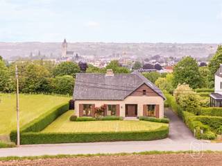 <p>Op een rustige en groene ligging in Oudenaarde bevindt zich deze vrijstaande woning met open zicht op de omliggende natuur. De woning combineert ruimte, comfort en een flexibele indeling, wat ze bijzonder geschikt maakt voor gezinnen of wie wonen en werken wil combineren.<br /><br />Wat maakt dit pand uniek?<br />Op het gelijkvloers word je verwelkomd in een ruime inkomhal met gastentoilet. Links bevindt zich een apart bureau met ingemaakte kasten, ideaal voor thuiswerk of een zelfstandige activiteit. Rechts ligt de ruime leefruimte met open haard en eetplaats, waar gezelligheid centraal staat. Aansluitend is er de keuken en een veranda die zorgt voor extra licht en een aangename verbinding met de tuin.<br /><br />De woning telt vier slaapkamers, waarvan elke kamer (met uitzondering van de master bedroom) voorzien is van een eigen lavabomeubel. Verder is er een verzorgde badkamer.<br />Op het tweede verdiep bevindt zich bovendien een extra gezellige zit- of leefruimte met apart toilet, wat tal van mogelijkheden biedt als ontspanningsruimte, hobbyruimte of extra leefruimte. Daarnaast is er nog een zoldergedeelte en een praktische berging onder het schuine dak.<br /><br />De woning is volledig onderkelderd en beschikt over een garage met poort en meerdere aparte, gemetste bergingen, ideaal voor stockage, provisieruimte of hobby’s.<br /><br />Voor wie is dit ideaal?<br />Deze woning is ideaal voor gezinnen, thuiswerkers of zelfstandigen die op zoek zijn naar een ruime, karaktervolle woning met veel praktische ruimtes, gelegen in een rustige en groene omgeving met toch een vlotte bereikbaarheid.</p>