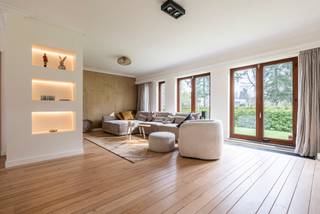 <p><strong>Ontdek deze ruime, recent gerenoveerde villa die gelegen is op een prachtig perceel van maar liefst 2.430 m² met ideale zuidwestoriëntatie, waar u in alle rust en privacy geniet van zon en groen. De villa omvat o.a. een lichtrijke woonkamer op parket met zithoek en eethoek, aansluitend een hoogwaardig vernieuwde keuken, die voorzien werd van alle moderne apparatuur, met tuinzicht en berging/wasruimte. Gelijkvloers 3 slaapkamers en een moderne badkamer. Verdieping met 2 ruime slaapkamers, tweede badkamer en polyvalente ruimte. Dubbele inpandige garage. Dankzij de aanwezigheid van airco’s doorheen de ganse woning geniet u bovendien steeds van een aangenaam binnenklimaat, ook tijdens warme zomerdagen. Energiezuinig met EPC B, zonnepanelen, warmtepomp (airco) en recente isolatiewerken. Instapklaar met onderhoudsvriendelijke tuin en ruime parkeermogelijkheden.</strong></p>
<p><span>Indeling gelijkvloers</span><br />Bij het binnenkomen via de royale inkomhal met gastentoilet en vestiaire ervaart u meteen de logische indeling en het aangename ruimtegevoel. Vanuit de hal wordt de woning mooi opgedeeld tussen leef- en nachtgedeelte.</p>
<p>Aan de linkerzijde bevindt zich de lichtrijke woonkamer op parket, stijlvol ingedeeld in een gezellige zithoek/tv-hoek en een ruime eethoek. De aansluitende, volledig vernieuwde keuken biedt een mooi zicht op de tuin en is praktisch ingericht. Via de keuken bereikt u de berging/wasruimte, met toegang tot de kelder én een bijkomende trap naar de verdieping.</p>
<p>Aan de rechterzijde van de inkomhal bevindt zich het nachtgedeelte op het gelijkvloers. Hier vindt u een recent gerenoveerde badkamer, uitgerust met een ruime inloopdouche, ligbad en toilet. Verder zijn er drie volwaardige slaapkamers, waarvan één momenteel ingericht is als bureau. Op het einde van de hal bereikt u de ruime dubbele garage met twee sectionaalpoorten.</p>
<p><span>Verdieping</span><br />Op de volledig afgewerkte verdieping bevinden zich nog twee bijzonder ruime slaapkamers en een tweede badkamer met douche en toilet. Tussen beide kamers bevindt zich een polyvalente ruimte, ideaal als bureau, speelkamer of hobbyruimte.</p>
<p>De woning werd bovendien energetisch geoptimaliseerd met zonnepanelen, warmtepomp (airco) en recente isolatiewerken, wat resulteert in een gunstig EPC-label B. Het dak werd tevens gerenoveerd.</p>
<p>De buitenruimte vormt een absolute meerwaarde: het ruime perceel biedt tal van mogelijkheden, voldoende parkeergelegenheid en een ideale zuidwestoriëntatie om maximaal te genieten van zon, rust en privacy.</p>
<p><span>Bijzonderheden:</span></p>
- Instapklare, ruime villa (430m²) met 5 slaapkamers<br />- Gelijkvloers wonen mogelijk<br />- Duurzaam – gunstig EPC<br />- Onderhoudsvriendelijke tuin<br />- Dubbele, inpandige garage<br />- Zonnepanelen<br />- Airco’s doorheen de ganse woning<br />- Extra comfort tijdens warme zomerdagen<br />- Laadpaal (3-fase - 22kw mogelijk)