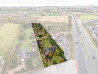 Op een perceel van maar liefst 5.643 m² bevindt zich deze vrijstaande te renoveren woning in Kruisem, deelgemeente van Gavere. Dankzij de zuidgerichte tuin, de grote oppervlakte én de vlotte bereikbaarheid richting N60, Gent en Oudenaarde, is dit een opportuniteit voor wie op zoek is naar ruimte en vrijheid met een centrale ligging.<br /><br /><u><strong>Indeling van de woning</strong></u><br />De bestaande woning heeft een bewoonbare oppervlakte van ca. 225 m² en biedt een klassieke, ruime indeling:
<ul>
	<li>Gelijkvloers: inkomhal, lichtrijke leefruimte, keuken, drie slaapkamers, een badkamer, bureauruimte en logeerkamer</li>
	<li>Verdieping: drie bijkomende kamers + grote zolderruimte met potentieel voor extra afwerking of berging</li>
	<li>Kelder &amp; Garage: inpandige garage met onderliggende kruipkelder</li>
	<li>Tuin: volledig zuidgericht, met mooi uitzicht op het achterliggende groen en volledige privacy</li>
	<li>Extra: op het perceel bevindt zich ook een ruime, aparte werkplaats of opslagruimte, ideaal voor zelfstandigen, hobbyisten of als bijkomende bergruimte.</li>
</ul>
<br /><u><strong>Stedenbouwkundige informatie – Zonevreemde woning</strong></u><br />Deze eigendom is gelegen in agrarisch gebied en wordt juridisch beschouwd als een zonevreemde woning. Er zijn geen verkavelingsvoorschriften, RUP of BPA van toepassing. Hierdoor gelden de basisrechten voor zonevreemde woningen zoals bepaald in art. 4.4.10 t.e.m. 4.4.19 van de VCRO:
<ul>
	<li>Verbouwen, herbouwen of uitbreiden is mogelijk met een maximum brutovolume van 1.000 m³</li>
	<li>Bij herbouw op dezelfde plaats is minstens 75% overlap vereist met de bestaande inplanting</li>
	<li>Bij herbouw op een andere plaats op het perceel gelden extra voorwaarden:
	<ul>
		<li>De aanvraag moet goed gemotiveerd zijn (betere integratie in de omgeving, efficiëntere terreinbezetting…)</li>
		<li>De nieuwe voorbouwlijn moet aansluiten bij deze van de naburige bebouwing of overeenstemmen met de courante inplantingswijze</li>
	</ul>
	</li>
	<li>Het aantal woonentiteiten mag niet vermeerderd worden</li>
	<li>Meergezinswoningen of tweede bouwlijn zijn niet toegestaan</li>
</ul>
<br /><u><strong>Unieke kans voor renovatie of heropbouw</strong></u><br />Deze eigendom biedt veel mogelijkheden voor wie op zoek is naar een woning met karakter, ruimte en herontwikkelingspotentieel. Of u nu kiest voor een volledige renovatie of een nieuwbouwproject binnen het toegestane volume: de combinatie van ligging, bereikbaarheid, perceeloppervlakte en oriëntatie is zeldzaam.<br /><br />Mis deze kans niet en contacteer ons voor meer informatie, documenten, plannen of om een bezoek in te plannen.