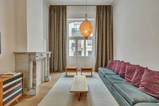 <p>Gelegen in de Egide Walschaertsstraat, op wandelafstand van het Sint-Gillisvoorplein, het park van Vorst en het Wiels, stellen wij u dit elegante duplexappartement voor van ±155m² + tuin. Bij de inkom vallen de volumes meteen op: plafonds van 4,30m met sierlijke moulures, overvloedig lichtinval en hoogwaardige materialen. Op het gelijkvloers bevinden zich een leefruimte van 35m², een eetkamer en een open keuken met strak design, die uitkomt op een balkon met zicht op de binnentuin. Op de benedenverdieping bevindt zich de slaapzone met twee slaapkamers (18m² en 11m²), een bureau, een aansluitende douchekamer bij de hoofdslaapkamer en een aparte badkamer. Een toilet onder de trap benut de ruimte optimaal. Het appartement wordt volledig gemeubeld verkocht en beschikt over conforme elektriciteit, een individuele gascondensatieketel. Gemeenschappelijke kosten: 125€/maand (slechts 4 mede-eigenaars in het gebouw). Met veel smaak gerenoveerd in de geest van het originele modernistische gebouw, biedt dit pand een stijlvolle en harmonieuze woonomgeving, waarin elk detail kwaliteit en architectonische coherentie uitstraalt. Een uitzonderlijk eigendom, zeldzaam op de markt, ideaal voor wie modern comfort zoekt in een karaktervolle setting.</p>