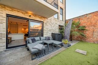 <strong>Instapklaar compact luxe-appartement (2021) met zonnetuin, terras & carport nabij centrum Brasschaat!</strong><br /><br /><strong>Plannen, indeling layout met afmetingen zie VIRTUAL TOUR ( KLIK )</strong><br /><br />Bent u op zoek naar het comfort van een villa, maar dan zonder het zware onderhoud? Dit hoogwaardig afgewerkte gelijkvloersappartement (bouwjaar 2021) combineert pure luxe met een uitzonderlijk energielabel (EPB E31!). Gelegen in een kleinschalig, modern gebouw van slechts 5 entiteiten geniet u hier van rust, privacy en een unieke sfeer, op wandelafstand van het bruisende centrum van Brasschaat.<br /><br /><strong>Zon, sfeer & buitenleven:</strong> de absolute blikvanger is de gezellige, west-georiënteerde privétuin (34 m²). Het aangelegde terras met ingewerkte palmboom en onderhoudsvriendelijk kunstgras ademt een instant vakantiegevoel uit, met directe toegang tot de carport. <br /><br />
<ul>
<li><strong>Indeling & Luxueuze afwerking: </strong>lichte design-leefruimte: Een zonovergoten woonkamer op een strakke, moderne keramische XL-tegel. De kamerhoge schuiframen zorgen voor een naadloze overgang naar de tuin.</li>
<li><strong>Open luxe-keuken:</strong> een modern, greeploos wit designeiland met een hoogwaardig naadloos werkblad (Corian/composiet) dat prachtig overloopt in een geïntegreerde eettafel. Volledig ingericht met topapparatuur (inductiekookplaat, vaatwasser, oven, grote koelkast en aparte diepvriezer) en stijlvolle, zwarte led-railverlichting.</li>
<li><strong>Mastersuite met hotel-vibe</strong>: Een royale, rustgevende slaapkamer met kamerbreed raam naar de tuin, die direct aansluit op de luxueuze open badkamer. Deze is voorzien van een royale inloopdouche met een strakke glazen wand en grote, zandkleurige wandtegels, een design-lavabomeubel met ingebouwde kraan en een slim weggewerkte maatkast voor wasmachine/droogkast.</li>
<li><strong>Sanitair & Techniek</strong>: Apart gastentoilet en een handige technische berging.</li>
</ul>
<strong>Technisch topcomfort:</strong><br />Het appartement is uitgerust met behaaglijke vloerverwarming over het volledige oppervlak, een individuele gascondensatieketel en een C-plus ventilatiesysteem. Dit resulteert in een extreem laag energieverbruik (E-peil: E31).<br /><br /><strong>Syndicus - lage maandelijkse lasten:</strong> slechts € 89/maand - syndicus, blokpolis/brandverzekering, bankkosten en gemeenschappelijk water & elektriciteit van de hal. <br />
<div><br /><strong>De perfecte match</strong> voor <strong>starters</strong>, <strong>singles of koppels</strong> <strong>die op zoek zijn naar een luxueuze thuis zonder renovatiezorgen. Eveneens ideaal voor wie kleiner wil gaan wonen met behoud van comfort & minder onderhoud, óf als een direct renderende, zorgeloze investering.</strong><span></span></div>
<div></div>
<div></div>