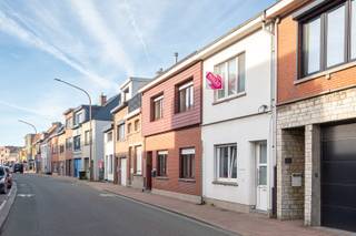 Deze gezellige starterwoning bevindt zich op een centrale en goed bereikbare locatie, met winkels, scholen en openbaar vervoer in de nabije omgeving. Je woont hier rustig, maar toch met alle voorzieningen binnen handbereik — ideaal voor wie comfort en bereikbaarheid belangrijk vindt.<br /><br />Bij het binnenkomen word je ontvangen in de inkomhal, van waaruit je via een deur de sfeervolle zitkamer binnenstapt. Deze ruimte is afgewerkt met een mooie parketvloer en geniet dankzij de grote ramen van veel natuurlijke lichtinval, wat meteen zorgt voor een warme en uitnodigende sfeer. De zitkamer loopt door naar de eetkamer, die eveneens baadt in het daglicht. Deze lichtrijke ruimte vormt het centrale punt van de woning en biedt voldoende plaats voor een eettafel. Hier bevindt zich ook de trap naar de bovenverdieping, wat zorgt voor een vlotte en logische circulatie.<br />Aansluitend kom je in de keuken, die praktisch is ingericht en uitgerust met een oven en veel kastruimte. Deze ruimte is voorzien van een tegelvloer, net als de achterliggende badkamer. De badkamer beschikt over zowel een bad als een aparte douche en is afgewerkt met een lavabo en lavabomeubel. Het aparte toilet, eveneens met deur, biedt extra privacy en comfort.<br /><br />Op de bovenverdieping bevinden zich twee volwaardige slaapkamers, allebei afgewerkt met parket en ruim genoeg voor een dubbel bed, kasten en eventueel een bureau. De warme vloerafwerking en het praktische formaat maken deze kamers veelzijdig inzetbaar — ideaal als master bedroom, kinderkamer, hobbyruimte of thuiskantoor.<br /><br />Hoewel het EPC van 337 (label D) ruimte laat voor verbetering, biedt dit pand veel potentieel voor wie graag zelf moderniseert en de woning verder wil afwerken naar eigen smaak. Dankzij de charmante uitstraling, de logische indeling, de mooie lichtinval en het gezellige karakter vormt dit huisje een ideale starterswoning voor singles of koppels.