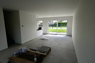 Indeling : inkomhal , apart toilet , woonkamer met open keuken , berging . <br />Verdieping 1 : 3 slaapkamers , badkamer met bad en douche , apart toilet , wasberging . <br />Verdieping 2 : slaapkamer + zolderkamer.<br /><br /><br />Terras en tuin .<br /><br />Er zijn 2 open autostaanplaatsen inbegrepen . <br /><br />zonnepanelen voorzien . <br /><br />Huur 1450 euro + 50 euro gemeenschappelijke kosten . <br /> 