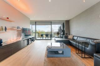 Dit instapklaar en ruim appartement vinden we terug op het Kolonel Dusartplein, aan de binnenzijde van de kleine ring van Hasselt. Bij het buitenstappen sta je pal in het bruisende centrum van Hasselt. Er zijn 2 ruime terrassen van 21m² en 14m² met een prachtig zicht over het plein. <br /><br />Indeling:<br />Het appartement is toegankelijk via trap en lift, per verdieping bevinden zich slechts 2 appartementen die gebruik maken van de lift. Via de veiligheidsdeur betreden we de inkomhal van het appartement. Van hieruit gaan we verder naar de leefruimte van 78m² met open keuken. In de leefruimte is er een op maat gemaakte bureau gecreëerd. Wat meteen opvalt is de zee van licht die gecreëerd wordt dankzij de kamerbrede en plafondhoge ramen. De kwalitatieve materialen wo. de parketvloer geven het geheel een luxueuze uitstraling. Er is een waterdamphaard aangesloten aan de waterleiding en deze zit verwerkt in het tv/audio meubel.<br />De open keuken is compleet uitgerust.<br />De ruime terrassen zijn goed georiënteerd en zijn tevens voorzien van verlichting. <br />Via de nachthal krijgen we toegang tot de master bedroom met ensuite dressing. Aansluitend bevinden er zich nog 2 ruime slaapkamers. Centraal ligt de mooie en praktische badkamer. Het appartement is voor de rest ook voorzien van verschillende op maat gemaakte opbergkasten wat het geheel ook uiterst praktisch maakt. Er zijn 2 toiletten nl. het gastentoilet en de andere vinden we terug in de badkamer.<br />De ruime wasplaats is voorzien in de technische berging.<br /><br />In de kelder bevindt zich nog een ruime en makkelijk bereikbare staanplaats en een ruime kelderberging. Er is nog een extra parking bij aan te kopen.<br />De parking bereik je heel makkelijk via de kleine ring of via de Koning Boudewijnlaan. Het betreft een gedeelte van de Q-parking wat enkel toegankelijk is voor bewoners van de residentie.<br />In de kelder is er tevens een gemeenschappelijke fietsenstalling en containerlokaal voorzien.<br /><br />Buitengewone kenmerken:<br />- Zéér goede ligging<br />- Instapklaar<br />- Prachtig zicht<br />- 143m² bruikbare oppervlakte (bron EPC)<br />- 3 slaapkamers<br />- 2 terrassen<br />- Breedte gevoel appartement <br />- Energiezuinig EPC A<br />- Kelderberging incl.<br />- 1 autostaanplaats incl. <br />- 1 autostaanplaats bij aan te kopen<br />- 2 inkomdeuren aangezien 2 appartementen samengesmolten zijn.