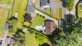 <h2><span>Charmante vrijstaande villa met 4 slaapkamers, poolhouse, buitenkeuken en dubbele garage op een toplocatie in Halle-Zoersel</span></h2><p><span>Op een rustige en bijzonder gegeerde locatie in Halle-Zoersel bevindt zich deze verzorgde vrijstaande villa, waar ruimte, comfort en gezelligheid centraal staan. De woning is gelegen op een mooi perceel en biedt een ideale combinatie van rustig wonen, een uitstekende bereikbaarheid en alle dagelijkse voorzieningen in de onmiddellijke omgeving. Dankzij de nabijheid van winkels, scholen, openbaar vervoer en belangrijke verbindingswegen geniet u hier van een bijzonder aangename woonomgeving.</span></p><h2><span>Indeling van de woning</span></h2><p><span>Deze verzorgde vrijstaande woning werd doordacht ingedeeld en combineert ruime leefvertrekken met een praktische gezinsindeling. Dankzij de grote raampartijen geniet elke ruimte van een aangename lichtinval.</span></p><h3><span>Gelijkvloerse verdieping</span></h3><p><span>Via de karaktervolle inkomdeur betreedt u de ruime inkomhal met vestiaire en een afzonderlijk gastentoilet. De centrale hal vormt het hart van de woning en geeft toegang tot alle leefruimtes alsook de trap naar de eerste verdieping.</span></p><p><span>Aan de linkerzijde bevindt zich de bijzonder ruime leefruimte, bestaande uit een gezellige zithoek en een volwaardige eetkamer. Door de grote raampartijen aan zowel de voor- als achterzijde geniet deze ruimte de hele dag van veel natuurlijk licht en een mooi zicht op de tuin. De woonkamer biedt voldoende plaats voor een groot salon en een royale eetplaats, waardoor het de ideale ruimte vormt om familie en vrienden te ontvangen.</span></p><p><span>Aansluitend bevindt zich de ruime leefkeuken. Deze beschikt over een praktische opstelling met veel werk- en kastruimte en biedt plaats voor een dagelijkse ontbijttafel of eethoek. Vanuit de keuken heeft u rechtstreeks toegang tot het terras en de tuin, waardoor binnen- en buitenleven naadloos in elkaar overvloeien.</span></p><p><span>Grenzend aan de keuken bevindt zich een praktische was- en bergplaats, uitgerust met aansluitingen voor wasmachine en droogkast, technische voorzieningen en extra opbergmogelijkheden. Vanuit deze ruimte is eveneens de tuin bereikbaar.</span></p><p><span>Verder beschikt de woning over een ruime inpandige garage met voldoende plaats voor een wagen, fietsen en bijkomende opslagruimte.</span></p><h3><span>Eerste verdieping</span></h3><p><span>De nachthal geeft toegang tot vier volwaardige slaapkamers.</span></p><p><span>De master bedroom is bijzonder ruim opgevat en biedt voldoende plaats voor een kingsize bed, grote kleerkasten en eventueel een aparte dressinghoek.</span></p><p><span>De tweede slaapkamer is eveneens ruim bemeten en kan perfect dienst doen als kinderkamer, logeerkamer of bureau.</span></p><p><span>Ook de derde slaapkamer beschikt over comfortabele afmetingen en geniet van een aangename lichtinval.</span></p><p><span>De vierde slaapkamer is ideaal als extra slaapkamer, bureau, hobbyruimte of thuiswerkplek.</span></p><p><span>Centraal op de verdieping bevindt zich de ruime badkamer, ingericht met een ligbad, afzonderlijke douche, dubbele wastafel en een tweede toilet. Dankzij de royale oppervlakte kan deze badkamer zonder probleem door een gezin worden gebruikt.</span></p><h3><span>Buitenomgeving</span></h3><p><span>De woning is omgeven door een fraai aangelegde tuin waar rust en privacy centraal staan.</span></p><p><span>Absolute blikvanger is het stijlvolle </span><span>poolhouse</span><span>, dat volledig is ingericht als ontspanningsruimte. Hier bevindt zich eveneens een volledig uitgeruste </span><span>buitenkeuken met ingebouwde barbecue</span><span>, waardoor het een ideale plaats is voor gezellige zomeravonden, familiefeesten of tuinrecepties.</span></p><p><span>Daarnaast beschikt het perceel over een </span><span>extra ruime vrijstaande garage of atelier</span><span>, die tal van mogelijkheden biedt. Deze ruimte is perfect geschikt voor meerdere wagens, een oldtimer, een camper, een zelfstandige activiteit, een hobbyatelier of extra opslag.</span></p><p><span>De ruime terrassen sluiten perfect aan op zowel de leefruimte als de keuken en zorgen ervoor dat de tuin optimaal benut kan worden gedurende het volledige jaar.</span></p><h3><span>Samengevat</span></h3><ul><li><span>Ruime inkomhal met vestiaire </span></li><li><span>Gastentoilet </span></li><li><span>Zeer lichtrijke woonkamer met zithoek en eetplaats </span></li><li><span>Ruime leefkeuken met zicht op de tuin </span></li><li><span>Praktische berging/wasplaats </span></li><li><span>Inpandige garage </span></li><li><span>Vier volwaardige slaapkamers </span></li><li><span>Ruime badkamer met ligbad, douche, dubbele lavabo en toilet </span></li><li><span>Aangelegde tuin met veel privacy </span></li><li><span>Luxueus poolhouse </span></li><li><span>Buitenkeuken met ingebouwde barbecue </span></li><li><span>Extra ruime vrijstaande garage/atelier </span></li><li><span>Oprit met voldoende parkeergelegenheid </span></li></ul><p><span>Deze woning combineert een klassieke, tijdloze architectuur met een bijzonder praktische indeling en een uitzonderlijke buitenaccommodatie. Hierdoor vormt ze de ideale gezinswoning voor wie op zoek is naar ruimte, comfort en een kwalitatieve woonomgeving in het groene Halle-Zoersel.</span></p>