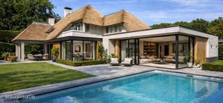<p><strong>In de gegeerde residentiële verkaveling De Lint in Oud-Turnhout vinden we deze bijzonder ruime en charmante villa, ontworpen door architect Hertroijs. Een woning met klasse, warmte en een uitzonderlijke totaalbeleving—rustig wonen, maar toch centraal, op slechts 25 minuten van zowel Eindhoven als Antwerpen.</strong></p>
<p>De villa beschikt over een nieuwe rieten kap, goed voor decennialang zorgeloos wooncomfort. In de prachtig aangelegde tuin geniet u van een vernieuwd en verwarmd buitenzwembad en een sfeervolle vijver die het buitenleven een haast vakantiesfeer geven.<br />Bovendien is inruil van uw eigen woning mogelijk, wat de aankoop extra toegankelijk maakt.</p>
<p><span><strong>Indeling</strong></span><br />De ruime inkomhal vormt een stijlvolle entree, geeft uit naar het gastentoilet en de bureauruimte alsook naar de verschillende leefruimtes van de woning. De royale woonkamer baadt in natuurlijk licht en geniet dankzij grote raampartijen van een continu zicht op de tuin. De volledige gelijkvloerse verdieping is afgewerkt met een prachtige natuurstenen vloer in combinatie met vloerverwarming, wat zorgt voor een warm en luxueus wooncomfort.</p>
<p>De heerlijke leefkeuken, uitgerust met geïntegreerde eetkamer en een gezellige tv-hoek, vormt het hart van het huis. Aansluitend bevindt zich de praktische wasruimte met achterliggend een apart toilet en douche, ideaal voor zwembadgasten. Verder is er een inpandige garage voor twee wagens.</p>
<p>Op de verdieping bevinden zich vier slaapkamers, een afzonderlijke dressing en twee badkamers. De dressing werd oorspronkelijk als vijfde slaapkamer ingetekend en kan indien gewenst eenvoudig opnieuw als slaapkamer worden ingericht.<br />De hoofdslaapkamer beschikt over een ensuite luxe badkamer met ligbad, douche, toilet en dubbele wastafel. De tweede badkamer is gemeenschappelijk en bevindt zich aan de nachthal. Op deze verdieping werd deels gekozen voor een massief eiken parketvloer, wat de ruimtes een warme, tijdloze uitstraling geeft.</p>
<p><strong>Deze villa biedt een unieke combinatie van karakter, ruimte, luxe en natuurrust op een van de mooiste locaties van Oud-Turnhout. Een uitzonderlijke kans voor wie exclusief én comfortabel wil wonen.</strong></p>