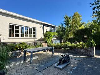 Deze mooie statige woning op een commerciële locatie biedt verrassend veel mogelijkheden. Omwille van het hoekperceel is de woning zowel via de Gentseweg als de Staakmolenstraat bereikbaar. De woning bestaat uit een woongedeelte, 3 slaapkamers, ruime lichtrijke leefruimte en keuken, statige inkom en zonneterras. Het geheel is volledig onderkelderd en voorzien van een grote garage. Aansluitend is er een recente en volledige studio, dewelke kan dienen als extra woonst maar tevens uitermate geschikt is voor een praktijk of burelen. Ook dit deel beschikt over een badkamer, keuken, leefruimte en 2 slaapkamers. Het grote voordeel is dat beide entiteiten in elkaar overlopen maar toch gescheiden zijn qua ingang. Tevens heeft elk woongedeelte een eigen vernieuwde CV ketel en aparte elektriciteitskast. De grote tuin zorgt voor de nodige privacy en rust en is voorzien van verschillende zonneterrassen. <br /><br />Echt een bezoekje waard !<br /><br />De villa wordt aangeboden met een richtprijs van 475.000€