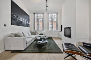 Op een absolute toplocatie in Schilde, op wandelafstand van het centrum en op een boogscheut van het gezellige kerkplein met hotspot Café Den Toren, presenteren wij deze prachtig gerenoveerde dorpswoning. Deze exclusieve eigendom combineert de authentieke charme van een karaktergevel, de hoogwaardige en uiterst smaakvolle binnenafwerking resulteren in onmiddellijk en zorgeloos genieten van alle luxe en comfort.
Bij het betreden van de woning ervaart u meteen een overweldigend gevoel van ruimte en elegantie. De riante, hoge plafonds trekken het daglicht rijkelijk naar binnen en versterken het open karakter. De verfijnde parketvloeren lopen naadloos door de leefruimtes en stralen een tijdloze warmte uit. Samen met de op maat gemaakte, stijlvolle raamdecoratie vormt dit een harmonieus geheel dat tot in de puntjes is verzorgd. In de sfeervolle zithoek geniet u tijdens koude winteravonden van de gezellige warmte van een moderne pelletkachel. De leefruimte sluit naadloos aan op een intieme, perfect ingesloten stadskoer. Deze buitenruimte is bewust compact gehouden, zodat u in alle rust, privacy en zonder onderhoud buiten kunt eten en relaxen.
Op de verdieping beschikt de woning over drie slaapkamers waarvan één ruime master bedroom, een tweede slaapkamer in gebruik als kantoor en de derde slaapkamer als combinatie dressing / logeerkamer en een moderne badkamer. Parkeercomfort in de dorpskern is bovendien gegarandeerd en inbegrepen in de vraagprijs: recht tegenover de woning bevindt zich een private ondergrondse staanplaats, ideaal voor het veilig stallen van fietsen of een compacte stadswagen. Een zeldzame opportuniteit voor wie op zoek is naar een instapklare woning met klasse en cachet in Schilde.