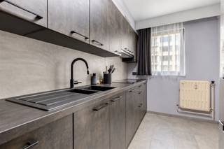 <h3><span>Ruim appartement met 2 slaapkamers op gunstige locatie in Mechelen</span></h3><p><span>Dit ruime appartement van </span><span>98 m²</span><span> geniet van een uitstekende ligging op wandelafstand van het centrum van Mechelen. Dankzij de vlotte verbinding met de </span><span>E19</span><span> en de nabijheid van beide treinstations, winkels, scholen en openbaar vervoer is het appartement bijzonder goed bereikbaar.</span></p><p><span>Bij het betreden van het appartement komt u terecht in de </span><span>inkomhal met praktische vestiairekast</span><span>, die toegang biedt tot de verschillende ruimtes. De ruime woonkamer sluit aan op de </span><span>vernieuwde keuken (2022)</span><span> en vormt samen een gezellige leefruimte.</span></p><p><span>Aan de rustige achterzijde van het appartement bevinden zich </span><span>2 slaapkamers en de badkamer</span><span>. Beide slaapkamers bieden toegang tot een </span><span>breed balkon met 2 praktische bergkasten</span><span>, waar u in alle rust van de buitenlucht kunt genieten. Daarnaast beschikt het appartement over een </span><span>apart toilet</span><span> en voldoende bergruimte.</span></p><p><span>Bovendien hoort er een </span><span>private kelderberging</span><span> bij het appartement gelegen op verdieping -2 en is er een gemeenschappelijke fietsenstalling op verdieping -1.</span></p><p><span>Voor extra comfort kan er een </span><span>ondergrondse autostaanplaats in het naastgelegen gebouw</span><span> worden aangekocht voor </span><span>€ 20.000</span><span>.</span></p><p><span>Een ruim en praktisch appartement met een </span><span>centrale ligging en uitstekende bereikbaarheid</span><span> ideaal voor wie comfortabel wil wonen vlak bij het centrum van Mechelen.</span></p>