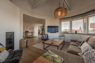 Res. Maryland. <br /><br />Op een gegeerde ligging in Duinbergen, op slechts enkele passen van de zeedijk, bevindt zich dit uitzonderlijk verzorgd dakappartement. Een unieke woonbeleving waar licht, ruimte en privacy harmonieus samenkomen, met prachtige open zichten als permanente achtergrond.<br /><br />De lift brengt u rechtstreeks in het appartement en mondt uit in een elegante inkomzone die de verschillende leefruimtes op een vloeiende manier met elkaar verbindt. De royale leefruimte geniet dankzij meerdere gevels en de bijzondere dakarchitectuur van een overvloed aan natuurlijk daglicht. De sfeervolle zithoek met gashaard vormt een warm en stijlvol geheel, terwijl de eetplaats naadloos aansluit op de keuken — ideaal voor zowel intieme diners als gezellige ontvangsten.<br />Het zongerichte terras is een absolute troef. Hier geniet u in alle discretie van open zichten en optimale bezonning. De geïntegreerde bureauhoek, subtiel opgenomen in de leefruimte, biedt een inspirerende werkplek met maximale lichtinval.<br />Het nachtgedeelte is duidelijk afgescheiden en waarborgt rust en comfort. Het appartement beschikt over twee volwaardige slaapkamers, waarvan één met bijkomende slaaphoek — perfect als extra logeerruimte of dressingmogelijkheid.<br />De sanitaire ruimtes zijn doordacht ingericht en bieden alle comfort:
<ul>
	<li>Een elegante badkamer met ligbad en wastafel</li>
	<li>Een afzonderlijke douchekamer met dubbele lavabo en toilet</li>
	<li>Een praktische berging/technische ruimte met wasvoorzieningen</li>
</ul>
Dankzij de unieke vormgeving, de plafondhoogtes en de aanwezigheid van meerdere gevels geniet dit dakappartement vrijwel overal van een uitzonderlijke lichtinval en een gevoel van openheid.<br />Een zeldzame opportuniteit voor wie op zoek is naar een verfijnde en zorgeloze woonervaring aan zee — ideaal als exclusieve vaste woonst of stijlvol tweede verblijf in Duinbergen.<br />Ref. A725 