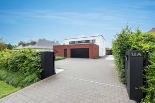 <p><strong>Ruime woning met multifunctionele studio</strong></p>
<p>In een <strong>rustige en aangename woonwijk</strong> te <strong>Vlimmeren</strong> bevindt zich deze verrassend ruime woning boordevol mogelijkheden voor <strong>grote gezinnen</strong>, <strong>thuiswerkers</strong> of wie op zoek is naar een combinatie van wonen, werken en ontspannen onder één dak.</p>
<p>De woning onderscheidt zich door haar <strong>royale leefruimtes</strong> en de aanwezigheid van een <strong>volledig aparte studio met eigen ingang</strong>. Deze multifunctionele ruimte biedt tal van mogelijkheden en kan perfect ingericht worden als <strong>zorgwoning</strong>, <strong>praktijkruimte voor een vrij beroep</strong>, <strong>kantoor</strong>, <strong>hobbyruimte</strong>, <strong>gastenverblijf</strong> of als woonunit voor een inwonend familielid. Dankzij de verbinding via de <strong>ruime garage</strong> blijven beide delen van de woning bovendien praktisch met elkaar verbonden.</p>
<p>Bij het betreden van de hoofdwoning komt u terecht in een <strong>ruime inkomhal</strong>, die toegang biedt tot de verschillende leefruimtes. De <strong>lichtrijke woonkamer</strong> vormt samen met de <strong>royale leefkeuken met kookeiland</strong> het hart van de woning. Aansluitend bevinden zich een bijkeuken en een <strong>speelkamer</strong>, die eveneens perfect kan dienen als bureau of hobbykamer.</p>
<p>Op de verdieping bevinden zich twee bijzonder ruime slaapkamers, waaronder een <strong>master bedroom</strong>, aangevuld met een <strong>grote dressing/inloopkast</strong>, een badkamer en een apart toilet. De extra leefruimte op deze verdieping biedt bovendien de mogelijkheid om, mits enkele beperkte aanpassingen, een <strong>volwaardige derde slaapkamer</strong> te creëren.</p>
<p>De studio beschikt over een eigen inkomhal, een aangename leefruimte met <strong>open keuken</strong>, een slaapkamer, bergruimte, een badkamer en een apart toilet. Hierdoor kan deze ruimte volledig zelfstandig functioneren en biedt ze maximale flexibiliteit voor diverse woon- of beroepsdoeleinden.</p>
<p>Ook buiten heeft deze woning heel wat te bieden. De <strong>volledig omheinde tuin</strong> garandeert optimale privacy en vormt een heerlijke plek om te ontspannen. Het <strong>zwembad</strong> zorgt voor een extra vleugje luxe en vakantiegevoel, terwijl de ruime, dubbele garage voldoende plaats biedt voor voertuigen, fietsen en extra opslagruimte.</p>
<p>Een eigendom dat dankzij haar <strong>ruimte</strong>, <strong>veelzijdigheid</strong> en <strong>uitstekende indeling</strong> perfect inspeelt op de woonnoden van vandaag en morgen. Een unieke opportuniteit voor wie op zoek is naar een woning met net dat beetje meer.</p>