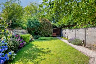 <p><span><strong>Ruime gezinswoning met tuin nabij het centrum van Retie.</strong></span><br /><br />We betreden de woning via de inkomhal, die meteen toegang biedt tot de leefruimte en de trap naar de eerste verdieping. De leefruimte voelt aangenaam en huiselijk aan, met een vaste kastenwand die perfect dienstdoet als tv-meubel en een charmante sierhaard die karakter toevoegt aan het geheel.</p>
<p>Aansluitend bevindt zich de eetkamer in open verbinding met de leefruimte. Deze ruimte leent zich uitstekend voor gezellige diners of het ontvangen van gasten. Vanuit de eetkamer is er een vlotte doorgang naar de keuken, die voorzien is van het nodige comfort en voldoende opbergruimte.</p>
<p>De keuken staat in open contact met een lichtrijke veranda die ideaal is als ontbijthoek. Hier geniet je van een mooi uitzicht op de westgerichte tuin, compleet met een verzorgd terras en een praktisch tuinhuis. Daarnaast is er een aparte buitenberging voorzien, perfect voor het opbergen van vuilnisbakken of tuingereedschap.</p>
<p>Via de achteringang bereiken we een apart gastentoilet en de eerste badkamer. Deze is uitgerust met een douchecabine, een badkamermeubel met enkele wastafel en aansluitingen voor de wasmachine.</p>
<p>Op de eerste verdieping leidt de nachthal naar twee volwaardige slaapkamers. Verder is er nog een extra ruimte die perfect kan dienen als berging. De tweede badkamer beschikt over een ligbad, een toilet en een badkamermeubel met enkele wastafel.</p>
<p>Tot slot is er voor de woning voldoende ruimte om twee wagens te parkeren, wat het comfort van deze charmante woning nabij het centrum van Retie compleet maakt.</p>