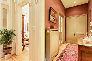 <p>The apartment is accessed via a welcoming entrance hall with built-in wardrobes. This leads to the living room, which immediately sets the tone with its beautiful archway, marble fireplace, mouldings, high ceilings, large windows and original herringbone parquet flooring,… this apartment is full of authentic features and enjoys an extremely stylish and classic appearance.</p>
<p>There is also a second lounge that can perfectly serve as a bedroom, office or hobby room.</p>
<p>The kitchen is equipped with a double sink, dishwasher, induction hob, extractor hood, eye-level oven and refrigerator. The utility room provides a practical space for a washing machine and dryer.</p>
<p>Furthermore, there is a second bedroom with an en-suite bathroom fitted with a double washbasin, walk-in shower and built-in wardrobes. The toilet is separate.</p>
<p>As the cherry on top, there is a particularly cosy terrace where you can relax and enjoy the peace and quiet.</p>
<p>Monthly charges: €275.00 (including water and heating).</p>
<p>Technical details: cellar with wine cabinet and built-in cupboards, insulated roof, wooden double glazing, security door, (fire) alarm system, videophone,…</p>
<p>The property is not located in a flood-risk area (P-score and G-score: C).</p>