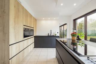 <p><span>Rustig wonen in een doodlopende straat, met alle voorzieningen binnen handbereik? Deze instapklare woning in Beringen ligt vlak bij Be-Mine, het centrum en de E313 en combineert ruimte, comfort en een praktische ligging.</span></p>
<p><span>De woning omvat op het gelijkvloers een inkomhal met gastentoilet, een aangename leef- en eetruimte en een volledig vernieuwde keuken (2022), aansluitend op de wasplaats/berging. De inpandige garage werd ingericht als studio en biedt mogelijkheden voor kangoeroewonen. Op de verdieping bevinden zich drie slaapkamers, waarvan de masterbedroom beschikt over een inloopdressing, en een vernieuwde badkamer (2020) met ligbad, toilet en dubbel lavabomeubel. Via een luik is een zolder bereikbaar, ideaal als extra bergruimte. Daarnaast beschikt de woning over een volledige kelder van ca. 95 m² met garage en doucheruimte. Buiten geniet u van een ruim perceel van 12a50ca met overdekt terras en dubbele carport. Er is bovendien voldoende parkeerruimte op het perceel.</span></p>
<p><span>Met een EPC-label C (296 kWh/m²) valt de woning niet onder de renovatieverplichting. De verwarming gebeurt op stookolie met vernieuwde brander; er is dubbele beglazing in meranti schrijnwerk en de ramen zijn voorzien van rolluiken. De elektriciteit is conform.</span></p>
<p><span>• Instapklare open bebouwing</span><br /><span>• Ruim perceel van 12a50ca</span><br /><span>• 3 slaapkamers + inloopdressing</span><br /><span>• Studio/kangoeroewonen mogelijk</span><br /><span>• Keuken (2022) en badkamer (2020)</span><br /><span>• Ca. 95 m² kelder</span><br /><span>• Dubbele carport en veel parkeerruimte</span><br /><span>• Rustige, doodlopende straat</span><br /><span>• EPC-label C – geen renovatieplicht</span></p>
