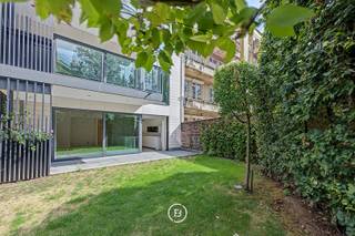 Situé au premier étage d'une résidence de standing, cet élégant appartement offre une superficie habitable d'environ 125 m² (selon le certificat PEB). Son agencement allie confort et fonctionnalité avec un vaste hall d'entrée comprenant un vestiaire et des toilettes invités. Le lumineux séjour s'ouvre sur une cuisine ouverte haut de gamme BULTHAUP et donne accès à une agréable terrasse d'environ 18 m².<br /><br />L'appartement dispose également d'une buanderie séparée. La suite parentale (env. 16 m²) comprend un dressing ainsi qu'une salle de bains attenante. Une seconde chambre bénéficie de sa propre salle de douche.<br /><br />La provision mensuelle pour les charges communes s'élève à 250 €.<br /><br />Parmi les nombreux atouts de ce bien figurent les placards intégrés, les rideaux inclus, l'excellente performance énergétique (PEB), une cave privative, un local commun pour vélos et poussettes ainsi qu'un local à déchets. Un emplacement de parking est disponible en option.