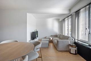In een kleinschalig gebouw, vlak bij het prachtige Rivierenhof en in een rustige straat, vind je dit tijdloos gerenoveerde appartement op de eerste verdieping. Het appartement werd in 2021 volledig gerenoveerd, met oog voor detail en behoud van authentieke elementen. Dankzij het kleinschalige karakter van het gebouw geniet je bovendien van bijzonder lage gemeenschappelijke kosten.<br /><br />Bij het binnenkomen kom je in de inkomhal, met een apart gastentoilet en toegang tot de stijlvolle badkamer. Verder kom je in de ruime en lichtrijke leefruimte, waar de charmante open haard zorgt voor extra karakter. Aansluitend vind je de open keuken met kookeiland, volledig afgewerkt in beton ciré. De keuken is uitgerust met een vaatwasser, inductiekookplaat met geïntegreerde dampkap, oven en koelkast met vriesvak. De open indeling biedt voldoende ruimte voor een gezellige eetruimte en een aparte zithoek.<br /><br />Het appartement beschikt over twee slaapkamers: een ruime hoofdslaapkamer voorzien van elektrische rolluiken en een tweede eenpersoonskamer. Via deze laatste heb je rechtstreeks toegang tot het ruime terras, waar je alle plaats hebt voor een gezellige loungehoek of eettafel.<br /><br />Extra troef voor investeerders: het appartement is momenteel verhuurd voor € 1.050 per maand en biedt dus onmiddellijk huurinkomsten.<br /><br />Bijzonderheden:<br />- EPC B<br />- Volledig gerenoveerd in 2021<br />- Elektriciteit conform<br />- 2 aparte kelder ruimtes<br />- Groot terras<br /><br />Wg, Vg, Gvkr, Gvv, Gmo, geen overstromingsgevoelig gebied