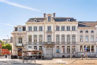 UNIEKE RETAILRUIMTE MET ENORM POTENTIEEL IN HISTORISCH RONSEDit indrukwekkende pand is gelegen op de meest prestigieuze locatie van Ronse, direct aan het charmante centrale plein van de stad. Met een totale bruikbare oppervlakte van 1000 m² en een grondoppervlakte van 398 m², biedt dit monument een uitzonderlijke kans voor ondernemers met visie.ARCHITECTURAAL ERFGOEDHet gebouw is een prachtig voorbeeld van 19de-eeuwse grandeur, met een voorkant die getuigt van Haussmannische elegantie. De gevel met zijn imposante steen- en ornamenten, decoratieve balustrades en gedetailleerde architraven straalt prestige uit. Het pand heeft bewaard kunnen blijven als een van de zeldzame originele structuren op het plein.RUIMTELIJKE MOGELIJKHEDENMet tien kamers verdeeld over verschillende verdiepingen, biedt dit pand flexibiliteit voor diverse bedrijfsmodellen. De begane grond is ideaal voor retailactiviteiten met rechtstreekse toegang vanaf het drukke plein. Verdiepingen bieden ruimte voor kantoren, opslagfaciliteiten of toekomstige uitbreidingen. De royale afmetingen van individuele vertrekken permetteren creatieve interieurontwerp.OPVALLENDE KENMERKENHet interieur toont sporen van voormalige grandeur met originele stucwerk, decoratieve plafonds met gouden ornamenten en indrukwekkende schouwmantels. De lange gangen en symmetrische indeling spreken van klassieke architectuur. Bakstenen muren en houten balkenstructuren geven authenticiteit. Grote ramen bieden natuurlijk licht en zicht op het levendige plein.STRATEGISCHE LIGGINGDirect aan het centrale plein van Ronse, een hoogtepunt van openbaar verkeer en voetgangersverkeer. Omgeven door cafés, winkels en cultuurhistorische monumenten. De positie garandeert maximale zichtbaarheid en bereikbaarheid.POTENTIEEL VOOR HERONTWIKKELINGDit pand vereist renovatie, wat tegelijkertijd authentieke elementen kan behouden. Ideaal voor projectontwikkelaars, hoteliers, kantoorgebruikers of gemengde culturele ondernemingen die het historische karakter willen respecteren en moderniseren.📩 Meer info of een bezoek op afspraak via Immo Beguin: info@immobeguin.be