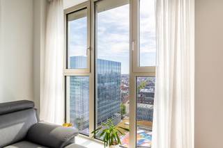 Dit appartement bevindt zich in de gegeerde Cadixwijk, pal naast het Eilandje. Hier woon je op wandelafstand van gezellige restaurants, bars en het Kempisch Dok, terwijl ook Park Spoor Noord vlakbij ligt. Dankzij de nieuwe tramverbinding, de heraanleg van de kaaien en de komst van het nieuwe ziekenhuis is deze buurt vandaag één van de meest populaire plekken om te wonen of te investeren in Antwerpen. Het appartement ligt op de 14de verdieping van de moderne residentie Doctoren (2022) en biedt een adembenemend uitzicht over de skyline van Antwerpen. De kamerhoge ramen zorgen voor overvloedig licht en een warme sfeer. De leefruimte met open keuken is praktisch en stijlvol ingericht en geeft uit op een zonnig privé-terras, perfect om te ontspannen met zicht over de stad. Verder zijn er twee slaapkamers, een verzorgde badkamer, een berging, een aparte gastentoilet en een private kelderruimte. Als extra troef is er het gemeenschappelijke dakterras met fenomenaal panorama over Antwerpen – dé plek bij uitstek voor gezellige momenten in openlucht of om even helemaal tot rust te komen. Meer info? www.walls.be - Epc: 66 kWh/m2 – E-peil: E42, P-score: C, G-score: C, Stedenbouwkundige gegevens in aanvraag