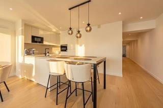 Op een uitzonderlijke toplocatie, op de hoek van de Zeedijk en de jachthaven van Blankenberge, bevindt zich dit stijlvol en tijdloos gerenoveerde appartement op de achtste verdieping van residentie 'Royale Phare'. Dankzij de unieke ligging geniet u van een adembenemend panoramisch uitzicht over de jachthaven, de duinen, de Noordzee én het hinterland. Vanaf het zonnige terras aan de voorzijde beleeft u elke dag opnieuw een schitterend schouwspel, met de late ochtend-, middag- en avondzon als extra troef.<br /><br />Binnen werd het appartement met oog voor detail en duurzame kwaliteitsmaterialen gerenoveerd. De tijdloze afwerking creëert een elegante en warme uitstraling, waardoor u hier jarenlang zorgeloos kunt genieten. De lichtrijke leefruimte sluit naadloos aan op de open, volledig uitgeruste kwaliteitskeuken, die zowel praktisch als stijlvol werd ingericht en over ruime opbergmogelijkheden beschikt.<br /><br />Via de nachthal bereikt u de smaakvol ingerichte badkamer, voorzien van een ruime inloopdouche, een groot badkamermeubel met enkele wastafel en extra wastafel in de hal voor het gastentoilet. De badkamer bevat ook de aansluitingen voor wasmachine en droogkast. Verder beschikt het appartement over twee volwaardige, lichtrijke slaapkamers waarvan één van beide uitgeeft op een tweede terras aan de achterzijde, waar u in alle rust kunt genieten. Een apart gastentoilet vervolledigt het geheel. Verder is er een fietsenberging op kelderniveau en werden de voor- en achtergevel geheel vernieuwd. <br /><br />Ook op technisch vlak scoort deze eigendom uitstekend, met centrale verwarming op aardgas, een conforme elektrische installatie en een gunstig EPC-label. Dankzij de hoogwaardige renovatie, de uitzonderlijke ligging en het fenomenale uitzicht vormt dit appartement de ideale vaste woonplaats, een luxueus tweede verblijf of een zorgeloze investering. Het meubilair kan desgewenst worden overgenomen, waardoor onmiddellijke ingebruikname of verhuur mogelijk is.<br /><br />