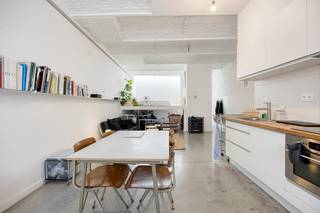 In de Spitaalpoortstraat, op de grens van Gent en Sint-Amandsberg, bevindt zich deze verrassend ruime studioloft van 78 m². Een eigendom met een uitgesproken loftgevoel, waar openheid, licht en karaktervolle architectuur centraal staan.<br /><br />Via de privatieve inkom komt u binnen in een ruime en lichtrijke leefruimte, waar wonen, koken en ontspannen op natuurlijke wijze in elkaar overvloeien. De combinatie van de witgeschilderde baksteen, de grote raampartijen en de robuuste vloer zorgt voor een bijzonder sfeervolle en eigentijdse woonbeleving.<br /><br />Achteraan in de loft bevindt zich een afzonderlijke slaaphoek, die op een slimme manier werd geïntegreerd in het geheel. Onder deze verhoogde slaapzone is bovendien praktische bergruimte voorzien. Hierdoor wordt de beschikbare oppervlakte optimaal benut zonder het open karakter van de loft te verliezen. <br /><br />Hoewel de eigendom op papier als studio wordt aangeduid, voelt deze woning door haar oppervlakte, indeling en ruimtelijkheid veel meer aan als een volwaardige loft. De open leefruimte biedt bovendien voldoende mogelijkheden om verschillende woonfuncties duidelijk van elkaar te onderscheiden.<br /><br />Ook technisch biedt de loft de nodige troeven: EPC-label B, vloerverwarming, een conforme elektrische installatie en een asbestveilig attest.<br /><br />Het gebouw bestaat uit slechts twee entiteiten, waardoor er geen syndicus is en de gemeenschappelijke kosten minimaal blijven.<br /><br />Momenteel wordt deze studio verhuurd voor € 825. <br /><br />Een karaktervolle stadsloft voor wie op zoek is naar ruimte, licht en een eigenzinnige woonbeleving, op een locatie waar Gent en Sint-Amandsberg samenkomen.<br /><br /><br />Bestuursmaatregelen in het maatregelenregister: nee