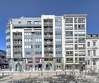 Dit unieke hoekappartement met een riant dakterras op de zesde verdieping biedt een uitzonderlijke ligging recht tegenover het oude justitiepaleis, op wandelafstand van zowel het centrum van Antwerpen als het Zuid. Dankzij de directe verbinding met de Antwerpse ring geniet de locatie bovendien van een uitstekende mobiliteitsscore.<br />Je wordt verwelkomd in een inkomhal met vestiaire en gastentoilet. De indrukwekkende, lichtrijke leefruimte (ca. 50 m²) springt meteen in het oog dankzij de iconische ronde voorgevel. Aansluitend bevindt zich de open leefkeuken (ca. 12 m²), uitgerust met afwasmachine, dampkap, kookplaat, oven, microgolfoven en een Amerikaanse koelkast met stenen werkblad. Vanuit de keuken heb je toegang tot een knus terrasje waar je ’s ochtends kan genieten van de zon en het historisch zicht op het oude justitiepaleis.<br />Via de nachthal met ingemaakte kasten bereik je een aparte berging met aansluiting voor wasmachine. De masterbedroom (21 m²) en tweede ruime slaapkamer (17 m²) liggen naast de volledig ingerichte badkamer met royaal ligbad, douche, dubbel badkamermeubel en toilet. Zowel de woonkamer als de masterbedroom geven uit op het grote terras (ca. 60 m²), perfect gericht om te genieten van de namiddag- en avondzon.<br />Het dak is conform en het appartement is energiezuinig (EPC 140 kWh/m²). Daarnaast is er een private kelderberging en is er mogelijkheid tot aankoop van een ondergrondse autostaanplaats voor €28.000.