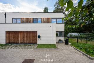 Bezoekdag op zaterdag 24 oktober 2026, uitsluitend na afspraak. <br /><br />In een rustige en kindvriendelijke woonomgeving in Wondelgem bieden wij deze hedendaagse BEN-woning aan, opgetrokken in halfopen bebouwing in 2020. De woning onderscheidt zich door een strakke architectuur, een kwalitatieve afwerking met hoogwaardige materialen en doordacht maatwerk, wat resulteert in een uitzonderlijk wooncomfort. De witte gevel, verfijnd met warme houten accenten aan de gevel en de garagepoort, geeft de woning een eigentijdse uitstraling. Achter deze gevel bevindt zich een instapklare gezinswoning waarin functionaliteit en esthetiek op harmonieuze wijze samengaan.<br /><br />Leefkeuken met karakter<br />De open leefkeuken vormt het hart van de woning. Een marmeren achterwand, een centraal eiland met dubbele spoelbak en discreet geïntegreerde designverlichting bepalen het verfijnde karakter van deze ruimte. Ze leent zich zowel voor het dagelijkse gezinsleven als voor het ontvangen van familie en vrienden.<br /><br />Doordachte indeling en hoogwaardig maatwerk<br />De woning biedt een bewoonbare oppervlakte van 158 m² en heeft een bijzonder functionele indeling. Op de verdieping bevinden zich drie slaapkamers. Eén ervan is momenteel ingericht als multifunctionele ruimte, met ingemaakte kasten, een bureau en een geïntegreerd opklapbed. Dankzij de uitgekiende inrichting en de ruime natuurlijke lichtinval kan deze kamer zowel als bureau, slaapkamer of logeerkamer worden gebruikt.<br /><br />De badkamer is eigentijds ingericht met een inloopdouche en een dubbel wastafelmeubel. De aansluitingen voor de plaatsing van een bad zijn reeds voorzien. Zowel op het gelijkvloers als op de verdieping bevindt zich een afzonderlijk toilet.<br /><br />Doorheen de woning werd gekozen voor onderhoudsvriendelijke keramische vloeren met vloerverwarming, aangevuld met airco. Accenten in marmer en eik en talrijke kamerhoge maatkasten zorgen voor een rustig en kwalitatief geheel, waarbij de beschikbare ruimte optimaal wordt benut.<br /><br />Troeven op een rij:<br />Instapklaar<br />Ingebouwde koffiecorner<br />Verfijnd maatwerk en hoogwaardige materialen<br />Vloerverwarming en airco doorheen de woning<br />Energiezuinige BEN-woning met zonnepanelen en laadpaal (thuisbatterij niet inbegrepen)<br />Geïntegreerd alarmsysteem<br /><br />Buitenruimte en garage<br />Achteraan geniet u van een aangenaam aangelegd terras en een onderhoudsvriendelijke tuin, omringd door groen. Een tuinhuis biedt bijkomende bergruimte. De inpandige garage biedt plaats aan een wagen en fietsen en staat rechtstreeks in verbinding met de woning.<br /><br />Ligging<br />De woning is gelegen in Wondelgem, ten noordwesten van Gent. De rustige, kindvriendelijke woonomgeving gaat hier samen met een vlotte bereikbaarheid van de belangrijkste invalswegen en het openbaar vervoer. Ook voor gezinnen is de ligging bijzonder gunstig. De Daltonschool (ca. 650 m) en basisschool Klimrek Van Belle (ca. 800 m) bevinden zich op korte wandel- of fietsafstand. Een apotheek, huisarts, park, speeltuin en supermarkten zoals Colruyt en Carrefour Express liggen allemaal binnen een straal van ongeveer één kilometer.<br /><br />Kortom: Een energiezuinige gezinswoning met een hoogwaardige afwerking, veel maatwerk en een uitzonderlijk praktische ligging.