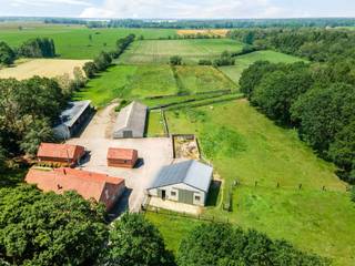 <p><span>Dans un endroit central près de Turnhout, vous trouverez cette propriété exceptionnelle sur plus de 9 ha de terrain.</span></p><p><span>Adjacente à une réserve naturelle et équipée de diverses dépendances, cette ferme est une opportunité unique pour ceux qui rêvent de vivre avec des chevaux à la maison. </span></p><p><span> </span></p><p><span>Ferme aménagée </span></p><p><span>Au centre de cette propriété se trouve un salon accueillant avec cheminée et plafond à poutres apparentes caractéristique, qui donne accès à une chambre avec dressing et salle de bain privée. L'espace de vie principal au rez-de-chaussée est la cuisine spacieuse située à l'arrière du bâtiment, composée d'une salle à manger et d'un espace cuisine avec îlot de travail. La cuisine est équipée de grandes fenêtres et donne ainsi accès à la cour. Une buanderie ou un débarras séparé et des escaliers menant au premier étage.</span></p><p><span>A l'étage se trouvent deux autres espaces de vie spacieux ou des chambres supplémentaires, une deuxième salle de bains et plusieurs armoires encastrées. Les pièces et les finitions du premier étage offrent de nombreuses possibilités, tant pour les amateurs'que pour les grandes familles. </span></p><p><span>Le garage intérieur offre un espace pour une voiture ainsi qu'une salle polyvalente ou un espace de stockage. </span></p><p><span> </span></p><p><span>Annexe</span></p><p><span>Derrière la ferme se trouve une dépendance d'environ 75 m² qui peut être utilisée comme atelier et espace de stockage et qui offre également suffisamment d'espace pour une voiture, par exemple. </span></p><p><span> </span></p><p><span>Maison d'hôtes</span></p><p><span>A l'arrière de la ferme se trouve également une petite dépendance qui peut être utilisée comme maison d'hôtes ou comme logement supplémentaire/cantine. </span></p><p><span> </span></p><p><span>Petite étable</span></p><p><span>Sur le côté droit de l'allée, il y a une grange d'environ 135 m² avec une hauteur libre considérable qui peut être utilisée comme remise ou comme étable. </span></p><p><span> </span></p><p><span>Grande grange </span></p><p><span>Située au centre de la propriété, cette grange a servi d'étable dans le passé et a une superficie d'environ 330 m². Ce bâtiment est plus ancien et nécessite quelques travaux d'entretien mais offre de nombreuses possibilités. </span></p><p><span> </span></p><p><span>Hangar</span></p><p><span>Sur le côté gauche de la propriété se trouve une grange ouverte de plus de 300 m² qui sert d'espace de stockage et en partie d'écurie. Cette structure offre également de nombreuses possibilités pour l'élevage d'animaux, ainsi que pour le stationnement de véhicules agricoles et autres. </span></p><p><span> </span></p><p><span>Prairies et terrains</span></p><p><span>Les différents bâtiments sont reliés entre eux par des pavés et des aires de stationnement. La majeure partie de la propriété est constituée de prés et de champs, qui sont divisés en pâturages pour l'élevage des chevaux. Il y a également un chemin qui mène à la réserve naturelle pour les promenades à cheval ou en calèche. </span></p><p><span> </span></p><p><span>Détails de la propriété </span></p><p><span>La propriété est située dans une zone agricole et se caractérise comme une résidence d'entreprise. L'année de construction originale est environ 1935, mais en 2005 la ferme a été entièrement rénovée et équipée du confort moderne. Le chauffage central est assuré par un système au fioul, et il y a également la climatisation. </span></p><p><span>La ferme comprend plusieurs espaces multifonctionnels qui offrent de nombreuses possibilités, telles que l'espace pour un membre de la famille ou du personnel, une salle de loisirs, une salle de répétition, etc.</span></p><p><span> </span></p><p><span>Plus d'informations auprès de notre bureau. </span></p>