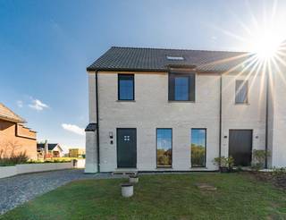 <h2><strong>Nieuwbouwcomfort met uitzicht op de velden: sfeervol wonen te Vertrijk</strong></h2><p>–<strong><strong>aankoopformule onder 21% BTW</strong></strong> <strong>(<strong>€</strong>635 250)</strong>–</p><p>Omringd door velden, met natuur als tweede thuis. Deze woning gelegen te Vertrijk vindt de perfecte balans tussen een serene ligging en beoogde bereikbaarheid. Gelegen in een rustige straat met weinig passage, te midden van het groen, terwijl bakker, slager, school en lokale handelaars op wandel- en fietsafstand liggen. Ook voor een wandeling door het omliggende landschap hoef je nauwelijks de deur uit. En wanneer de stad lonkt, ligt Leuven op amper 11 kilometer.</p><p>Gebouwd in 2025, is dit een thuis die vandaag een gegeerde drievuldigheid combineert: hedendaags comfort, een verfijnde afwerking en uitmuntende energieprestaties. En wie binnenstapt, voelt dit meteen: oog voor detail in elke lichtovergoten ruimte. Op het gelijkvloers trekt de keuken vanzelf de aandacht: stijlvol, duurzaam en met een rechtstreekse blik op de achterliggende tuin. Diezelfde zorg voor materiaal en afwerking komt terug in de moderne badkamer met inloopdouche. En naast de drie afgewerkte slaapkamers, wacht er op de bovenste etage nog een extra troef: een ruime zolder – al bereikbaar via een vaste trap – uitgerust met vloerverwarming. Van een royale hoofdslaapkamer tot een hobbystek: deze ruimte wordt ongetwijfeld jouw canvas voor alle wensen en noden die je ‘t liefst beleeft boven.</p><p>En dan is er het uitzicht; misschien wel het mooiste geschenk van deze woning. Het zuidoost gerichte perceel van meer dan 5 are strekt zich achteraan vrij uit over de velden. Een levend panorama, met jouw thuis er middenin. En ook technisch steekt dit huis er met kop en schouders bovenuit. Een lucht-waterwarmtepomp, vloerverwarming op elke verdieping en zonnepanelen (goed voor 5.220 Wp) tillen deze woning naar een uitzonderlijk energiezuinig niveau. Met een E-peil van -5 en label A+ bevindt ze zich vandaag ook in de topklasse op de markt. </p><p>Kortom: zie jij jezelf hier duurzaam toeven met een uitgestrekt zicht over de velden? Geef Jes dan snel een seintje, want combinatie als deze tref je zelden.</p><figure><div></div></figure>