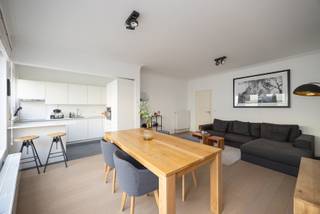 In a central and sought after location, you will find this move in ready apartment (85 m²) with two spacious bedrooms and a south facing terrace. Thanks to the high quality finish and well thought out layout, you will enjoy stylish living within walking distance of shops, restaurants, and public transport.

You enter the apartment through the entrance hall with cloakroom space and a separate guest toilet with hand basin. The bright living area spans the full width of the façade and offers a pleasant view thanks to the large windows. On the street side, there is a fully equipped, modern open corner kitchen.

A continuous parquet floor runs throughout the apartment and pairs perfectly with the clean architectural style. The bathroom is finished tastefully with a vanity unit, illuminated mirror, walk in shower, towel radiator, and connections for a washing machine and dryer.

Both bedrooms are located at the quiet rear of the apartment and provide direct access to the sunny terrace, where you can fully enjoy the south facing orientation.

Key features
• Central location with excellent accessibility
• Two spacious bedrooms
• Sunny south facing terrace
• Private cellar storage

Technical details: PVC double glazing, individual meters.
Common charges: 80 euros per month.
Urban planning information requested.