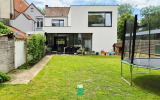 Knap gerenoveerde interbellum burgerwoning met behoud van authentieke elementen en heel wat troeven:<br />- Energie-efficiënt (EPC B)<br />- Asbestveilig<br />- Praktische indeling<br />- Oprit en dubbele garage, die ook voor andere doeleinden kan dienen<br />- Ligging<br />- 4 slaapkamers, 2 badkamers en 3 aparte toiletten<br /><br />STAAT:<br />Deze woning uit de jaren '40 werd in 2020 volledig gerenoveerd en uitgebreid met een mooi modern volume. De woning is nog niet tot in de puntjes cosmetisch afgewerkt, maar niettemin perfect instapklaar. De renovatiebudgetten zijn namelijk geïnvesteerd in de constructie en de technieken, alles volgens de regels van de kunst en met de degelijkste materialen. Zo zijn alle zichtbare en onzichtbare leidingen en installaties (ver)nieuw(d).<br /><br />INDELING<br />Je komt er binnen in een grote hal met een natuurstenen vloer die leidt naar boven, het salon, en een portaal met toegang tot de spinde, een gastentoilet en de keuken.<br />Het ruime salon baadt in een historische grandeur, toch werd ook deze ruimte flink onder handen genomen, zo werd de vloer geïsoleerd onder het originele parket. De monumentale schouw en pittoreske bar kleden de ruimte mooi aan.<br />De moderne aanbouw omvat eetplaats en de strakke, praktische keuken met marmeren werkblad. Veel opbergruimte aan beide zijden van het riante eiland en kamerhoge kasten, waarvan 1 een doorgang is naar de wasruimte/berging/technische ruimte. Daar bevindt zich ook de achterdeur naar de oprit, ideaal om de boodschappen te lossen waar ze horen.<br />Boven is het oorspronkelijk volume voorbehouden voor de kinderen, met 3 flinke kinderkamers , een douchekamer en een apart toilet. De nieuwe aangebouwde oudervleugel kom je binnen in een "dressinghal", die is geflankeerd door een omvangrijke kastenwand.<br />Hier is ook de ruime 2de badkamer met ligbad, douche en dubbele lavabo. Daarnaast heb je het aparte toilet en tenslotte de ouderkamer met weids zicht op het groen.<br />Er is ook een nog niet ingerichte zolder, waarvan de vloer is geïsoleerd en waar zich de ventilatie-unit.<br /><br />COMFORT:<br />De woning heeft reeds een EPC-label B en toch zijn er nog enkele 'quick wins', die geen dure investeringen vergen. Een heel goede basis dus. <br />Ventilatiesysteem is aanwezig. In het nieuwe gedeelte is er vloerverwarming onder de gepolierde betonnen vloer, boven ligt overal parket. Regenwater is aanwezig,<br />Buiten kan je genieten van de ruime tuin, waar je ook een dubbele garage vindt, die nu wordt gebruikt als enerzijds tuinberging en anderzijds speelkamer. In dat bijgebouw zijn alle nutsvoorzieningen aanwezig, zodat die ook relatief eenvoudig kan worden aangepast naar een atelier, studio, bureel, zorgwoning,...<br />Het is een halfopen bebouwing, met een brede oprit naar achter, waar meerdere auto's kunnen geplaatst worden.<br /><br />LIGGING:<br />De woning ligt op het beste plekje van de Baron Ruzettelaan, Je hebt er een voortuin met open zich op de vaart, op 5 minuten fietsen van de Katelijnepoort, dichtbij vele winkels,... De buurt wordt in de volgende jaren verder opgewaardeerd.<br /><br />Wonen in de Brugse rand met alle moderne comfort en knusse gezelligheid!