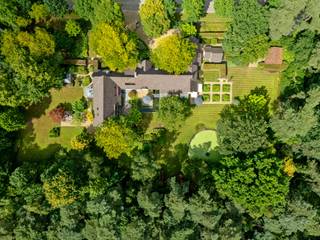 Oasis de calme, de luxe et de raffinement...<br /><br />Dans l'une des avenues les plus recherchées de Schilde, sur un vaste terrain d'environ 6 534 m², jouxtant une grande zone boisée, se trouve cette villa exceptionnelle d'une superficie habitable d'environ 881 m². La propriété allie une architecture intemporelle, une finition de haute qualité et une intimité absolue au milieu d'un jardin luxuriant.<br /><br />Classe architecturale et décoration élégante<br />Dès que vous empruntez l'allée d'entrée, vous êtes accueilli par une charmante façade recouverte de lierre, entourée d'arbres matures et de haies taillées avec élégance. À l'intérieur, une maison qui respire le calme et la classe se dévoile, avec une harmonie entre des matériaux chaleureux, des éléments d'intérieur élégants et une vue magnifique sur le jardin environnant.<br /><br />Le vaste espace de vie avec une hauteur de plafond imposante est baigné de lumière grâce à de grandes baies vitrées et offre un accès direct à la terrasse ensoleillée et au jardin. Le coin salon luxueux avec cheminée forme le cœur de la maison et invite à la détente. Ensuite, vous trouverez un coin lecture séparé, parfaitement aménagé avec des placards sur mesure et des accents élégants.<br />Par l'escalier, nous accédons à un premier étage. Cet espace nuit avec bureau nous mène à la grande chambre principale avec salle de bains attenante, dressing et vue sur le jardin.<br />Disposition avec confort en tête<br />La maison dispose de plusieurs salons, d'une salle à manger entièrement équipée et d'un espace bureau/réception séparé. La spacieuse cuisine ouverte est adjacente à un deuxième coin salon avec accès à la terrasse.<br />Par un deuxième escalier, nous atteignons l'autre premier étage. Celui-ci offre une suite d'invités avec salon, dressing, chambre à coucher, toilettes séparées et salle de bains attenante. Ensuite, une 3ème et 4ème chambre avec placards intégrés entre une salle de bains communicante.<br /><br />Installations de bien-être uniques et piscine intérieure<br />Un atout majeur est la magnifique piscine intérieure et le jacuzzi avec vue sur la verdure environnante, parfaitement intégrés à la maison et dotés d'un luxueux espace de détente avec bar et installations sanitaires. Avec le hammam, vous vivrez ici une véritable expérience de bien-être privée.<br /><br />Architecture de jardin de premier plan<br />Le jardin est un chef-d'œuvre en soi : entièrement aménagé avec plusieurs terrasses, des plans d'eau, des bordures taillées avec soin et de vieux arbres qui procurent une sensation de sécurité. Les différents coins salon garantissent calme et discrétion. Le jardin est orienté sud-ouest, ce qui assure un ensoleillement maximal et un magnifique jeu de lumière à l'intérieur.