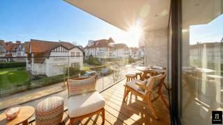 Subliem appartement in een nieuwbouwresidentie op een triple A ligging met overdekt zonneterras, genietend van prachtige open zichten op het groen en de villa's van het Zoute. Indeling: Inkomhal met vestiaire en gastentoilet. Lichtrijke leefruimte met zonneterras en open zichten op de villa's en het groen. Eetplaats met op maat gemaakte zitbank. Open keuken met Miele toestellen. Masterbedroom met dressing en aansluitend luxueuze douchekamer in marmer. Tweede volwaardige slaapkamer met aansluitend douchekamer. Beide slaapkamers geven toegang tot het terras achteraan. Praktische berging met aansluiting voor wasmachine en droogkast. Privatieve kelder. Afwerking: vloerverwarming, messing kranen, Italiaanse marmer, parket, ... Mog. overnemen huurcontract ruime garagebox aan de overkant van de residentie. Appartement met hoogstaande afwerking gelegen in het hart van het Zoute met mooi zichten en een groot zonneterras. Recente nieuwbouwresidentie met EPC = A.
