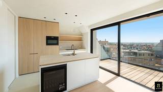 Appartement duplex neuf avec terrasses ensoleillées et une magnifique vue latérale sur la mer, situé sur la plage d'Albert. <br />Résidence moderne et intimiste, avec un seul appartement par étage. <br />L'appartement-terrasse a été entièrement aménagé (plafonds et murs peints dans une belle teinte écru texturée, spots encastrés et apparents, placards intégrés)...<br /><br />AGENCEMENT : Hall d'entrée avec toilettes invités et espace pour un vestiaire. Agréable salon donnant sur une belle terrasse ensoleillée offrant une superbe vue latérale sur la mer. Cuisine à vivre entièrement équipée avec îlot central (plan de travail en pierre), coin repas avec banquette en bois, donnant sur une agréable terrasse ensoleillée avec vue dégagée sur l’arrière-pays. Arrière-cuisine/débarras avec raccordement pour la machine à laver.<br />À l'étage : couloir avec salle de bains (douche, meuble-lavabo et WC), 2 grandes chambres pouvant accueillir un lit double.<br />Grande cave privée et local à vélos commun. Chauffage au sol géothermique (chauffage et climatisation possibles). Séparation entre la valeur du terrain et celle de la construction.
