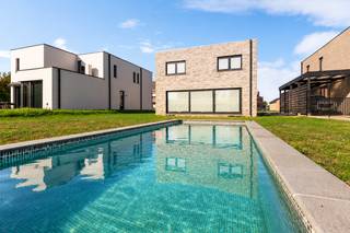 <p>Deze stijlvolle vrijstaande woning werd in 2024 gebouwd met bijzondere aandacht voor architectuur en hedendaags wooncomfort. Verscholen in het groene Noorderwijk, waar het gezellige dorpsleven en uitgestrekte landschappen hand in hand gaan, vind je hier alle ingrediënten voor een thuis waar rust en comfort de hoofdrol spelen.</p>
<p>Bij binnenkomst merk je meteen dat hier aan elk detail werd gedacht! Via een stijlvolle glazen deur stap je de zonovergoten leefruimte binnen. De royale raampartijen zorgen niet alleen voor licht en ruimte maar creëren ook een prachtige connectie met de tuin. Het zwembad vormt daarbij een absolute eyecatcher en geeft het buitenleven nét dat tikkeltje meer! Lange zomerdagen aan het water, gezellige avonden met vrienden vanop het gras of gewoon simpelweg helemaal tot rust komen in de tuin? Deze plek vormt het decor voor ontelbaar veel mooie herinneringen!</p>
<p>De trendy, open keuken werd ingericht met hoogwaardige materialen en kwaliteitsvolle toestellen, waarbij design en functionaliteit elkaar versterken. Verder ontdek je op het gelijkvloers nog een polyvalente kamer die zich perfect leent als bureau, hobbykamer of extra slaapkamer.</p>
<p>Via de houten trap bereik je de eerste verdieping, waar er nog maar liefst 4 riante slaapkamers op je wachten. Plek genoeg dus voor het hele gezin! Ook de badkamer is een plaatje op zich. De tegels in aardetinten zorgen voor een rustgevende luxueuze uitstraling, terwijl het comfortabel ligbad, de ruime inloopdouche en de dubbele lavabo in meubel zorgen voor een dosis welness in huis. Het toilet is apart.</p>
<p>Een eigen zwembad, een zee aan ruimte en een flinke dosis stijl. Klinkt als jouw droomwoning? Kom het zeker zelf eens ontdekken!</p>
<p><strong>Technische gegevens: EPC label A!! </strong>8 zonnepanelen aanwezig, regenwaterput van 5.000 liter. <strong>Tuinhuis voorzien. </strong></p>
<p><strong>Stedenbouwkundige inlichtingen en bodemattest aanwezig. Bevindt zich niet in een risicozone voor overstromingen (P- en G-score A). Renovatieverplichting en asbestattest niet van toepassing.</strong></p>