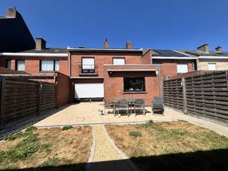 Deze verzorgde en instapklare gezinswoning (206 m²) is gelegen in een rustige, doodlopende straat en combineert comfort, ruimte en energiezuinig wonen. De woning beschikt over een oprit met garage en biedt zowel binnen als buiten heel wat praktische troeven.<br />Via de inkomhal, voorzien van een gastentoilet, komt u in de aangename leefruimtes. De keuken is volledig ingericht en uitgerust met alle nodige toestellen en sluit mooi aan bij de eetruimte. De gezellige leefruimte beschikt over een schuifraam naar de tuin, waardoor binnen en buiten mooi met elkaar verbonden worden. De tuin is ingericht met een tuinhuis, een aangenaam loungegedeelte en een terras met elektrische zonneluifel, ideaal om optimaal van de buitenruimte te genieten. In de leefruimte zijn bovendien een ingemaakte kast en tv-meubel voorzien. De woning is volledig uitgerust met verlichting en beschikt overal over elektrische rolluiken.<br />Op de eerste verdieping bevinden zich 3 volwaardige slaapkamers, aangevuld met een aparte hobbykamer die perfect kan dienen als bureau of extra bergruimte. De badkamer is uitgerust met een lavabo, douche, ligbad en toilet. Ook op deze verdieping zijn de elektrische rolluiken, glasgordijnen en verlichting reeds aanwezig.<br />Via het zolderluik in de nachthal bereikt u de volledig geïsoleerde zolder, die extra bergruimte biedt. Daarnaast beschikt de woning over een kleine kelder en een regenwaterput van 5.000 liter.<br />Een bijkomende troef zijn de 14 zonnepanelen, die bijdragen aan een lagere energiefactuur.<br />
