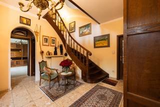 Meer info? wouter.beckx@homixx.be of 016/199.349<br /><br />Op een royaal perceel aan de Tuindijk 60 in Schriek bevindt zich deze statige villa uit de jaren 90. Met haar bijzonder ruime indeling, multifunctionele vertrekken en talrijke uitbreidingsmogelijkheden is dit een woning die zich moeiteloos aanpast aan uiteenlopende woon- en werkbehoeften.<br /><br />Via de royale inkomhal bereik je de keuken, eetkamer en aangename leefruimte. Op het gelijkvloers bevindt zich bovendien een afzonderlijke bureauruimte, die evengoed kan worden ingericht als slaapkamer, hobbykamer of praktijkruimte.<br /><br />De eerste verdieping telt drie volwaardige slaapkamers en een badkamer. De ruime zolder biedt daarnaast volop mogelijkheden om extra slaapkamers, een hobbyruimte of een andere invulling te creëren.<br /><br />Ook de volledig onderkelderde verdieping is een grote troef. Deze is momenteel ingericht als kinesitherapiepraktijk en beschikt over verwarming en airconditioning. De kelder sluit rechtstreeks aan op de inpandige garage, die plaats biedt aan twee wagens. Wie meer garageruimte wenst, kan een deel van de kelder hiervoor benutten. Uiteraard leent deze verdieping zich ook uitstekend voor een vrij beroep, hobbyruimte, fitness, opslag of andere doeleinden.<br /><br />Kortom: een karaktervolle villa met een enorme bewoonbare oppervlakte, een veelzijdige indeling en uitzonderlijk veel potentieel. Ideaal voor wie royaal wil wonen, wonen en werken wil combineren of op zoek is naar een woning die kan meegroeien met de toekomst.