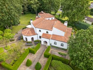 Deze unieke villa in Houthalen-Helchteren onderscheidt zich door haar karaktervolle architectuur met speelse rondingen en een tijdloze vormgeving. Gebouwd in 1998 en gelegen op een uitzonderlijk perceel van 4.470 m², biedt deze ruime woning met een bewoonbare oppervlakte van 394 m² alle troeven voor comfortabel wonen: royale leefruimtes, veelzijdige indelingsmogelijkheden en een uitstekende energie-efficiëntie.<br />De woning ademt karakter door haar organische vormen: van de eetkamer tot de zithoek met sierlijke halfronde ramen die het buitenlicht binnenhalen. De vele raampartijen zorgen doorheen de hele woning voor een warme, lichte sfeer die u onmiddellijk thuis doet voelen.<br /><br />Indeling: Master bedroom met aangrenzende badkamer, ruime leefruimtes en een sfeervolle keuken, grote berging en dubbele garage. Polyvalente ruimte (+-100m2): een grote extra ruimte die u naar eigen wens inricht als feestzaal, fitnessruimte, hobbyatelier of professionele werkzone, vrij beroep/kantoor en met rechtstreekse toegang door de grote kelder.<br /><br />Op de verdieping bevinden zich drie slaapkamers en een tweede badkamer — tevens inzetbaar als volledig autonome studio met eigen leefruimte, keuken, badkamer en twee slaapkamers. <br /><br />De volledige woning is onderkelderd (met plafondhoogte van 2.40m), goed voor +-263m2.<br /><br />Op een perceel van 4.470 m² geniet u van een indrukwekkende tuin die rust, ruimte en privacy biedt. Of u nu wilt ontspannen, tuinieren of buiten ontvangen — deze buitenruimte biedt het allemaal. De prachtige volwassen tuin biedt verschillende zon-en schaduwplekjes.<br /><br />Buitengewone kenmerken: <br />- Ruime woning van 394 m² <br />- Perceel van 4.470 m²<br />- Unieke architectuur met speelse rondingen en karaktervolle details<br />- 4 slaapkamers en 2 badkamers<br />- Verdieping bruikbaar als autonome studio<br />- Polyvalente extra ruimte (feestzaal, sport, atelier…)<br />- Dubbele garage en volledige kelder<br />- Veel natuurlijk licht dankzij grote raampartijen<br />- Mogelijkheid tot vrij beroep/kantoor aan huis<br />- Ruime tuin met veel privacy