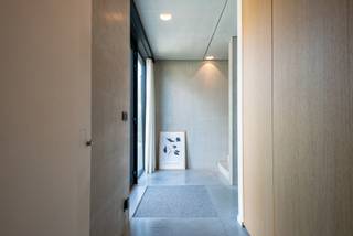 Deze moderne concrete house combineert hedendaags wooncomfort met een luxueuze afwerking op toplocatie. De woning is gelegen in een rustige, residentiële en vóóral een kindvriendelijke omgeving. De geothermische warmtepomp, hoogwaardige beglazing en 27 zonnepanelen zorgen voor een EPC-label “A” met een score van “8 kwh”. Dankzij de slaapkamer en aansluitingen voor een badkamer op het gelijkvloers, is gelijkvloers wonen perfect mogelijk.<br /><br /><strong>GELIJKVLOERS</strong><br />De ruime <strong>inkomhal van 15m²</strong> op polybeton beschikt over een gastentoilet en handenwasser.<br />Het <strong>bureel/slaapkamer van 12m²</strong> op polybeton biedt de mogelijkheid tot een aparte ingang en aansluiting voor een badkamer. Hierdoor is deze ruimte ideaal als bureel, slaapkamer of praktijkruimte.<br />De<strong> woonkamer van 30m²</strong> op polybeton beschikt over een bio-ethanolhaard. <br />Aansluitend bevindt zich de strakke <strong>leef-eetkeuken van 32m²</strong>, eveneens op polybeton, voorzien van een AEG-kookplaat, koelkast, diepvriezer, vaatwasser, stoomoven, combi-oven, warmhoudlade en spoelbak. Het kookeiland, de ontbijthoek en het werkblad in kwartsiet Solntorano zorgen voor een luxueuze uitstraling. Ook hier kan u genieten van de bio-ethanolhaard.<br /><br /><strong>De garage van 22m²</strong> op beton beschikt over een sectionale poort en auto/goederen lift.<br /><br />Vanuit de leefruimtes is er toegang tot het <strong>terras van 30m²</strong> op polybeton en het <strong>overdekte terras van 10m²</strong>. <br />De aangelegde tuin beschikt over tuinverlichting en een beregeningssysteem.<br /><br /><strong>KELDER 101M²</strong><br />De ondergrondse verdieping is een ware droom voor autoliefhebbers of kan dienstdoen als opslagruimte of magazijn.<br />De kelder beschikt tevens over een <strong>wasplaats van 9m²</strong> met waskoker en aansluitingen voor wasmachine en droogkast, alsook van een technische ruimte van 10m².<br /><br /><strong>1STE VERDIEPING</strong><br />De ruime <strong>overloop van 25m²</strong> op parket beschikt over een nachttoilet, linnenkasten en dressingkasten.<br />De <strong>hoofdslaapkamer van 15m² </strong>op parket sluit aan op de <strong>dressing van 10m²</strong> en de <strong>hoofdbadkamer van 12m²</strong> op tegel, voorzien van ligbad, inloopdouche en dubbel lavabomeubel.<br />Verder zijn er nog 2 <strong>slaapkamers </strong>van telkens <strong>15m²</strong> op parket. <br />De<strong> 2de badkamer van 6m²</strong> op tegel beschikt over een inloopdouche en enkele lavabo.<br /><br /><strong>BIJZONDERHEDEN</strong><br />Geothermische warmtepomp voor verwarming en koeling, vloerverwarming doorheen de hele woning, 27 zonnepanelen (12.000 kwh/jaar), laadpaal (22 kwh), domoticasysteem van Nico Home Control, driedubbele beglazing inbraakwerend, geluidsisolerend en zonwerend, pakjesbrievenbus, blokdeuren, geboord put, regenwaterput van 10.000 liter, beregeningsysteem, vaste vliegenhorren, dimmers en ingebouwde spots.<br /><br /><strong>POSITIEVE PUNTEN</strong><br />EPC-label A<br />Zonnige tuin<br />Auto/goederenlift<br />Rolstoeltoegankelijk<br />Co-housing mogelijk<br />Kindvriendelijke omgeving<br />Ideaal voor wonen/werken<br />Gelijkvloers wonen mogelijk<br />Rustige residentiële omgeving<br />Hedendaagse, luxueuze afwerking<br />Volledig aangelegde en omheinde tuin