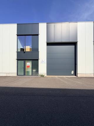 Gelegen langs het kanaal Dessel-Schoten. <br /><br />Automatische inrijpoort 4.50m hoogte x 4.00m breedte. <br />Vrije plafondhoogte : 7.00m<br />Binnenafmetingen 14,86m breed en een diepte van 24,83m <br />Met hout is de binneninrichting afgewerkt tot een kantoor/refter met een verdieping voorzien van 2 toiletten.<br /><br />Bijzonderheden: <br />- Brandmuren tussen de loodsen voorzien <br />- Rookluik en brandslang aanwezig <br />- Toiletten<br />- Lichtstraat centraal in de daken <br />- 2 parkeerplaatsen inbegrepen<br /><br />Voor meer info of een bezoek kan je Bart bellen op het nummer 0474/344.300