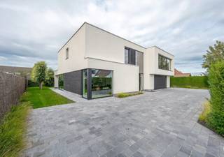 <p>Exclusieve villa met hoogstaande afwerking – Knokke, Kragendijk</p>
<p>Deze luxueuze woning op een perceel van 880 m² ligt in een rustige buurt van Knokke en biedt een royale bewoonbare oppervlakte van 438 m², verdeeld over twee verdiepingen. Een perfecte combinatie van ruimte, stijl en modern wooncomfort.</p>
<p>Indeling: Het gelijkvloers verwelkomt je met een ruime inkomhal, maatwerk vestiairekast, designverlichting en plafondhoge deuren in glas/metaal. De leefruimte is afgewerkt met eiken parket, inbouwspots met dimmers en elegante raamdecoratie. De open keuken is uitgevoerd in Nano Nero/Bianco met een zwart granieten werkblad en voorzien van kwaliteitsvolle inbouwtoestellen van Bosch en Novy.</p>
<p>Verder is er een gastentoilet met stijlvol wastafelmeubel en een garage voor 5 à 6 wagens, uitgerust met parkeerbrug, uitgietbak en dubbele sectionale poorten.</p>
<p>Verdieping: Boven zijn er 3 volwaardige slaapkamers met parket, inbouwverlichting en elektrische rolluiken. De master beschikt over een ruime dressing en een luxe badkamer met vrijstaand bad, inloopdouche en maatmeubilair. Er is tevens een multifunctionele bureauruimte of 4e slaapkamer, ingericht met biljarttafel en ingebouwde kasten.</p>
<p>Tuin: De volledig aangelegde tuin is voorzien van een blauwsteen terras, overdekt zithoekje met verlichting, een tuinhuis, maatwerk poorten en oprit met meerdere parkeerplaatsen. Het terrein is volledig afgesloten en biedt volledige privacy.</p>
<p>Een instapklare woning op toplocatie in Knokke – ideaal voor wie houdt van ruimte, luxe en verfijning.</p>