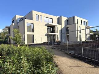 YES! Voor dit pand kan je zélf een afspraak inboeken! Ga naar de advertentie op onze website www.justwonen.be en plan meteen je afspraak in.<br /><br />Bloemenhof is een project om trots op te zijn. Echt. Want laat ons eerlijk zijn: niet élk appartementsgebouw is een meerwaarde voor ons dorp. Deze keer doen we het anders. Eindelijk. <br /><br />1. Niet wonen aan de drukte van de Grote Baan, maar in 4 kleinere residenties in een parktuin. Met respect voor de groene omgeving en de privacy van de bewoners. <br /><br />2. De appartementen werden extreem energiezuinig afgewerkt (E-peil 20), en voorzien van een warmtepomp, zonnepanelen, vloerkoeling, ventilatie, etc. Goed voor de natuur én je portemonnee. <br /><br />3. Ook ons niet-meer-zo-piepjonge publiek zetten we graag in de Bloemetjes. Erg toegankelijke appartementen, een lift tot in de parkeergarage, invalideparkeerplaatsen voor de deur en een supercentrale locatie. Even gaan lunchen in de Wouwer, een bezoekje brengen aan de bakker en beenhouwer of een tripje naar de stad met de bus: alles is op wandelafstand. <br /><br />4. De appartementen werden volledig geschilderd, dus enkel een tripje naar de Ikea, en je bent vertrokken. <br /><br />Wat dit stulpje je te bieden heeft, vraag je? <br /><br />Een cosy appartement van 65m op ’t eerste, met een balkon met fijn zicht op ’t groen. Lekker onderhoudsvriendelijk en compact wonen zonder dat je je opgesloten voelt. Verder zit dit appartement aan de achterzijde van het complex, dus heerlijk rustig vertoeven. <br /><br />Er is 1 slaapkamer aanwezig, met aansluitend een badkamer. Met voor de liefhebbers: een bad! <br />Ook is er een aparte wasruimte én een apart toilet. <br /><br />De auto zet je droog in je ondergrondse parkeerplaats, en er is nog een extra kelderberging om je terrasstoelen in de winter netjes op te bergen.<br /><br />Maandelijkse servicekosten: 75 EUR.