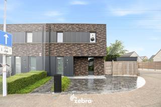 <strong>Het bezoekmoment gaat door op zaterdag 5 september 2026 (enkel op afspraak).</strong><br /><br />De woning (BJ 2015) combineert hedendaags wooncomfort met uitstekende energieprestaties dankzij vloerverwarming, een warmtepomp en zonnepanelen (11 stuks, 4785 Wp), goed voor een uitzonderlijk energiezuinig EPC-label A+. Verder beschikt de woning over diverse extra voorzieningen, waaronder domotica, een ventilatiesysteem D, een waterverzachter en een regenwaterput van 15.000 liter.<br /><br />Via de inkomhal met gastentoilet betreedt u de woning. De lichtrijke leefruimte met volledig uitgeruste open keuken vormt het hart van de woning.<br />De keuken werd afgewerkt met kwalitatieve materialen en is uitgerust met moderne toestellen, waaronder een inductiekookplaat met geïntegreerde afzuiging, twee combi-ovens, ... Aansluitend bevindt zich een praktische keukenberging.<br /><br />Op de eerste verdieping zijn er vier volwaardige slaapkamers (plat dak), allemaal voorzien van internet- en tv-aansluitingen. De ruime badkamer beschikt over een dubbele wastafel, ligbad en douche. Daarnaast is er een afzonderlijk toilet aanwezig.<br /><br />De zonnige, zuidwestgerichte tuin biedt een aangename buitenruimte en beschikt over een praktische uitweg naar de bijhorende garagebox, inbegrepen in de prijs. Verder zijn er een zonneluifel en een tuinhuis aanwezig. Via het poortje aan de rechterzijde van de woning is de tuin bovendien gemakkelijk bereikbaar.<br /><br /><strong>Ook wild geworden van deze thuis?<br />Twijfel niet langer en leg vandaag nog uw bezoek vast!</strong>
