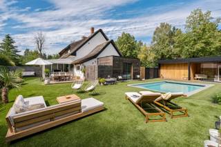 <p><span>Karaktervolle woning met rieten dak en verwarmd zwembad in Brasschaat</span></p><p><span>Troeven</span></p><p><span>Brasschaat is een van de groenste gemeenten van de Antwerpse rand, en dat voel je in deze rustige buurt meteen. Je zit hier vlak bij Kalmthout en Wuustwezel, en toch sta je in een paar minuten op de oprit richting Antwerpen of Breda. Een omgeving waar het aangenaam stil is zonder dat je iets moet inleveren op bereikbaarheid.</span></p><p><span> </span></p><p><span>Feiten</span></p><p><span>• Karakteristiek rieten dak, instapklaar</span></p><p><span>• Verwarmd zwembad met solarsysteem en wellnessruimte</span></p><p><span>• Volledig omheind perceel met automatische toegangspoort</span></p><p><span>• 3 slaapkamers, 2 badkamers en een extra multifunctionele ruimte</span></p><p><span>• EPC 164 kWh/(m² jaar), label B — elektriciteit conform</span></p><p><span> </span></p><p><span>Omschrijving — Wonen op het gelijkvloers, genieten in de tuin</span></p><p><span>Achter de automatische toegangspoort valt eerst het rieten dak op: het geeft deze halfopen woning een uitstraling die je in de buurt niet snel een tweede keer tegenkomt. De oprit biedt plaats aan 3 à 4 wagens.</span></p><p><span>Binnen loop je door naar de leefruimte en de eetplaats, die aansluiten op de keuken. De veranda vormt de overgang naar buiten en kijkt uit over de tuin en het zwembad.</span></p><p><span>Het vergunde bijgebouw herbergt een volwaardige slaapkamer met eigen badkamer. Een indeling die veel mogelijkheden opent: als master bedroom, als gastenverblijf, of voor wie graag gelijkvloers slaapt.</span></p><p><span>Op de eerste verdieping liggen 2 bijkomende slaapkamers en een extra ruimte die zich leent tot bureau, dressing, hobbyruimte of ruime berging. Daarboven is er nog een zolder met bijkomende opslagruimte.</span></p><p><span>De tuin is het hart van deze woning. Het perceel van 495 m² is volledig omheind en ingericht om er het hele seizoen door te zijn: een verwarmd zwembad met solarsysteem, een aansluitende wellnessruimte, hoogwaardig kunstgras dat het jaar rond groen blijft en meerdere plekken om de zon te volgen.</span></p><p><span>EPC 164 kWh/(m² jaar), label B. Elektrische keuring conform. Beschikbaar vanaf 15 december 2026.</span></p><p><span> </span></p><p><span>Zin om deze woning en haar tuin zelf te zien? Contacteer Christophe Matthys voor meer informatie of een afspraak.</span></p><p><span> </span></p>