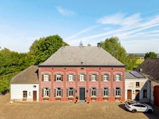 <p><strong>Exclusieve vierkantshoeve te koop in Arc-Wattripont – luxe, rust en authenticiteit </strong></p>
<p>Op een domein van drie hectare ligt deze uitzonderlijke vierkantshoeve, volledig gerenoveerd met behoud van haar authentieke charme. De eigendom biedt privacy, ruimte en verfijning in een idyllische, groene omgeving.</p>
<p>De hoofdwoning verwelkomt u met een statige inkomhal, bureauruimte, eetplaats, twee gezellige salons met haardvuur en een lichtrijke orangerie met uitzicht op de tuin. De landelijke keuken met Aga-fornuis sluit aan op een bijkeuken, wasplaats, berging, stookruimte en wijnkelder. Op de verdieping bevinden zich drie ruime slaapkamers, een dressing, twee badkamers, een fitnessruimte en een zolder met uitbreidingspotentieel.</p>
<p>Het buitengedeelte ademt luxe en rust: een zwembad van 12,50 bij 5.00 meter met een vorig jaar volledig vernieuwd Coverseal afdekking, poolhouse (sauna, douche, zithoek met haard), een overdekt terras met open zicht, stenen bakoven, gerenoveerde serre, vijver en een prachtige tuin met oude bomen. Daarnaast vindt u een conciergerie (vakantiehuis met 3 slaapkamers, keuken, salon, badkamer en wc), een grote schuur met indrukwekkend gebinte (perfect als feestzaal), paardenstallen (10 boxen), piste en weides.</p>
<p>Zonnepanelen zorgen voor energie-efficiëntie. Er is bovendien mogelijkheid tot aankoop van ca. zes hectare weides en grond.</p>
<p>Deze luxe hoeve in Arc-Wattripont is een unieke kans voor wie houdt van exclusief wonen in harmonie met de natuur. Een perfect evenwicht tussen elegantie, comfort en rust — klaar om in te trekken.<br /><br />Voor inlichtingen en/of bezoek, bel Stéphanie Eeckhout <strong>0472/13.28.79</strong></p>